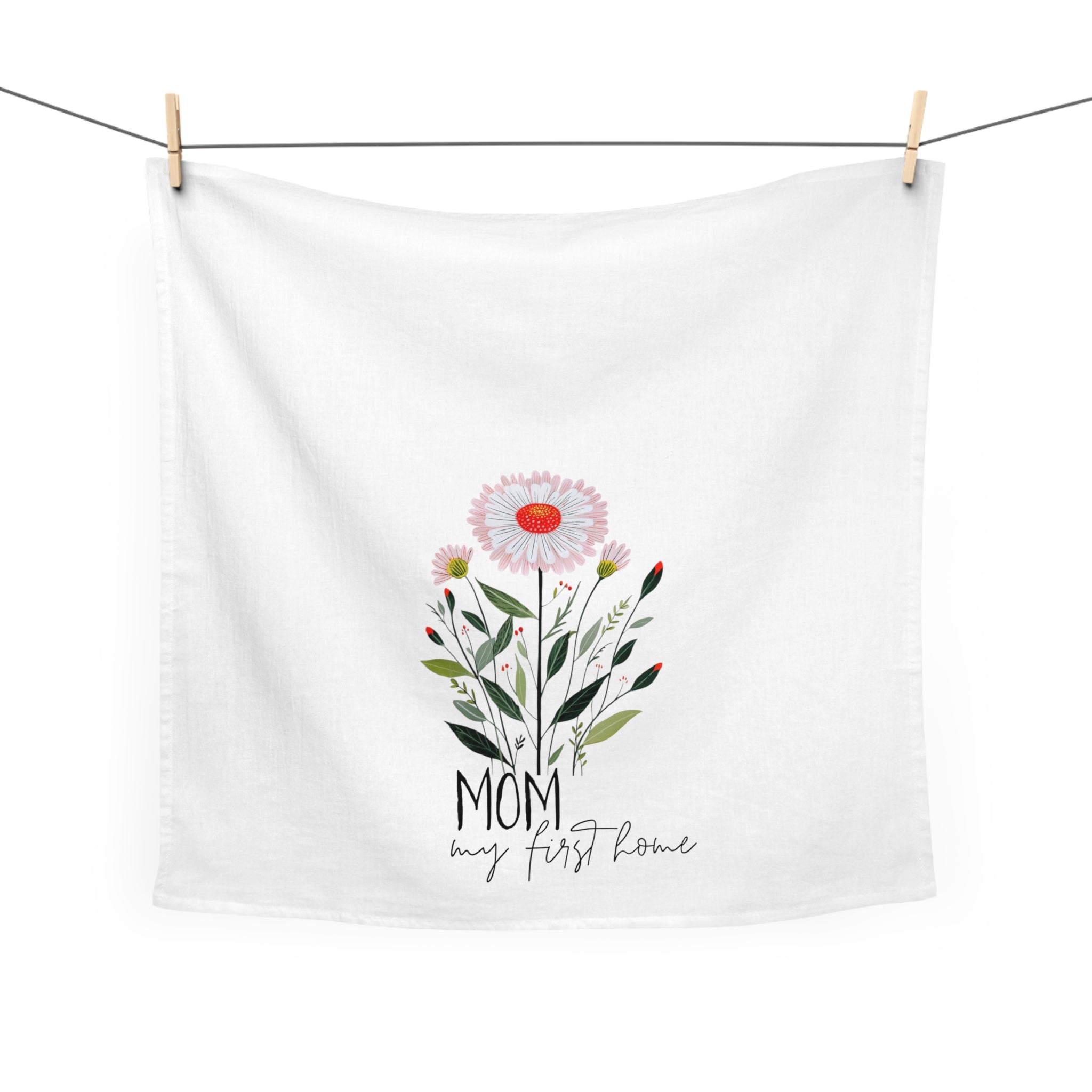 White towel with floral design and text hanging on a line
