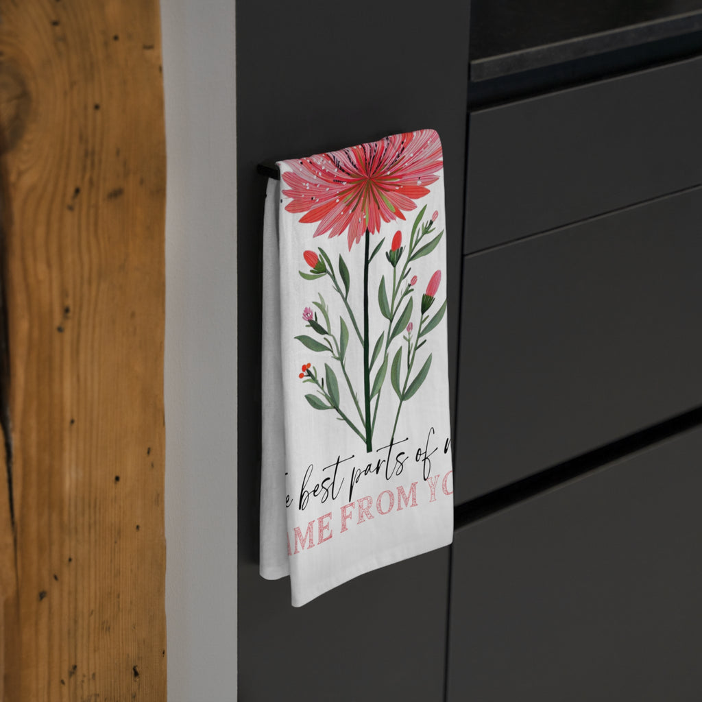 Floral design tea towel hanging on a black cabinet.