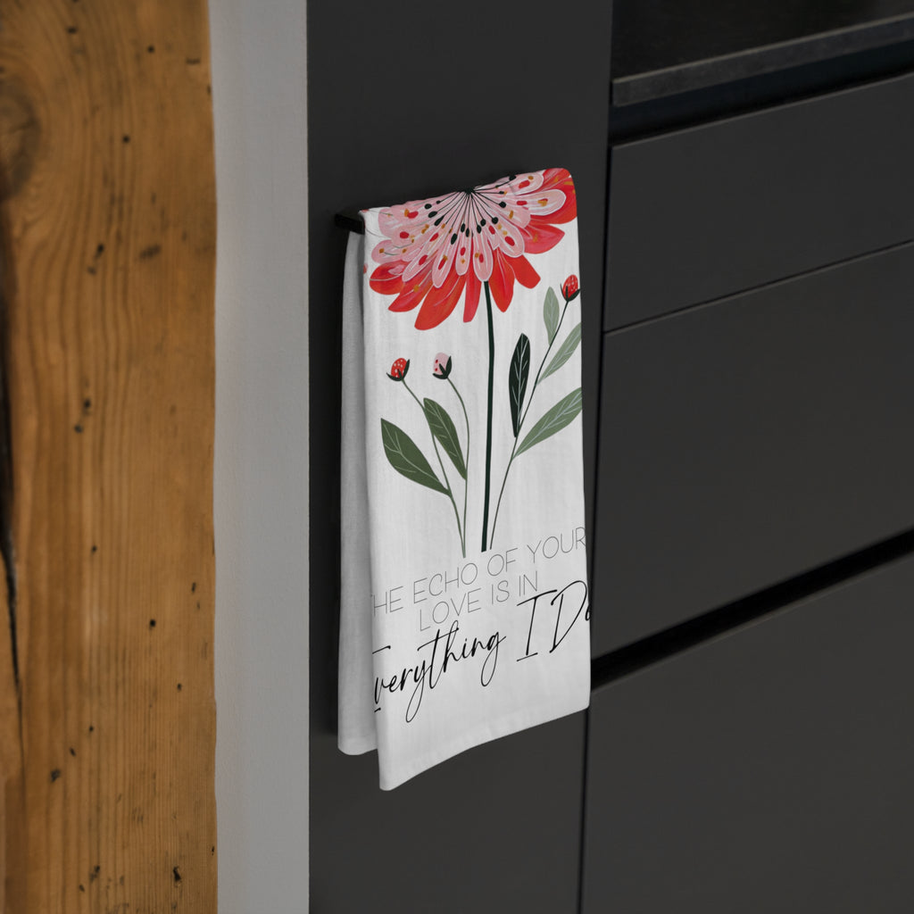 Floral towel with text hanging on a black cabinet.