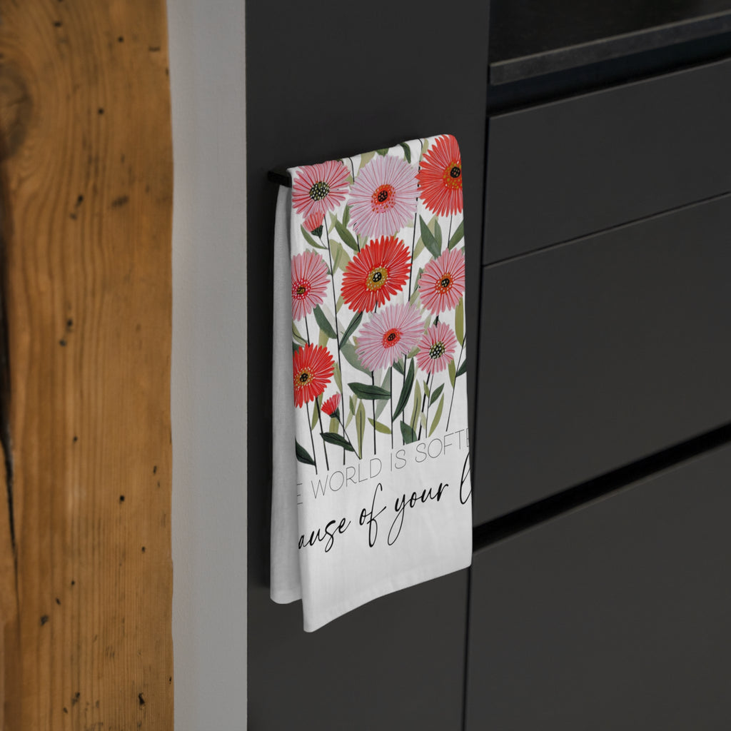 Floral patterned towel hanging on a black cabinet with wooden wall background