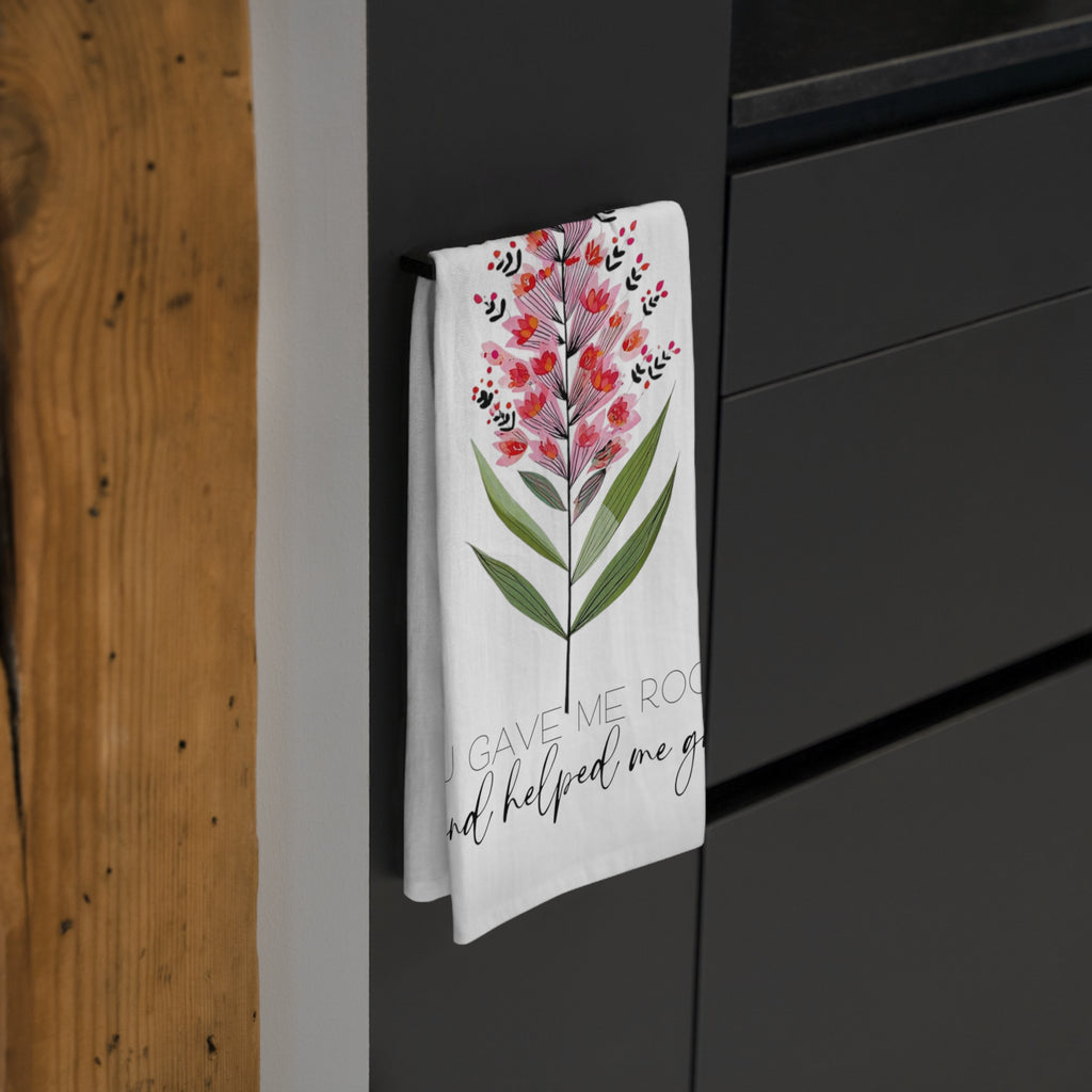 Floral towel hanging on a black cabinet with wooden wall background