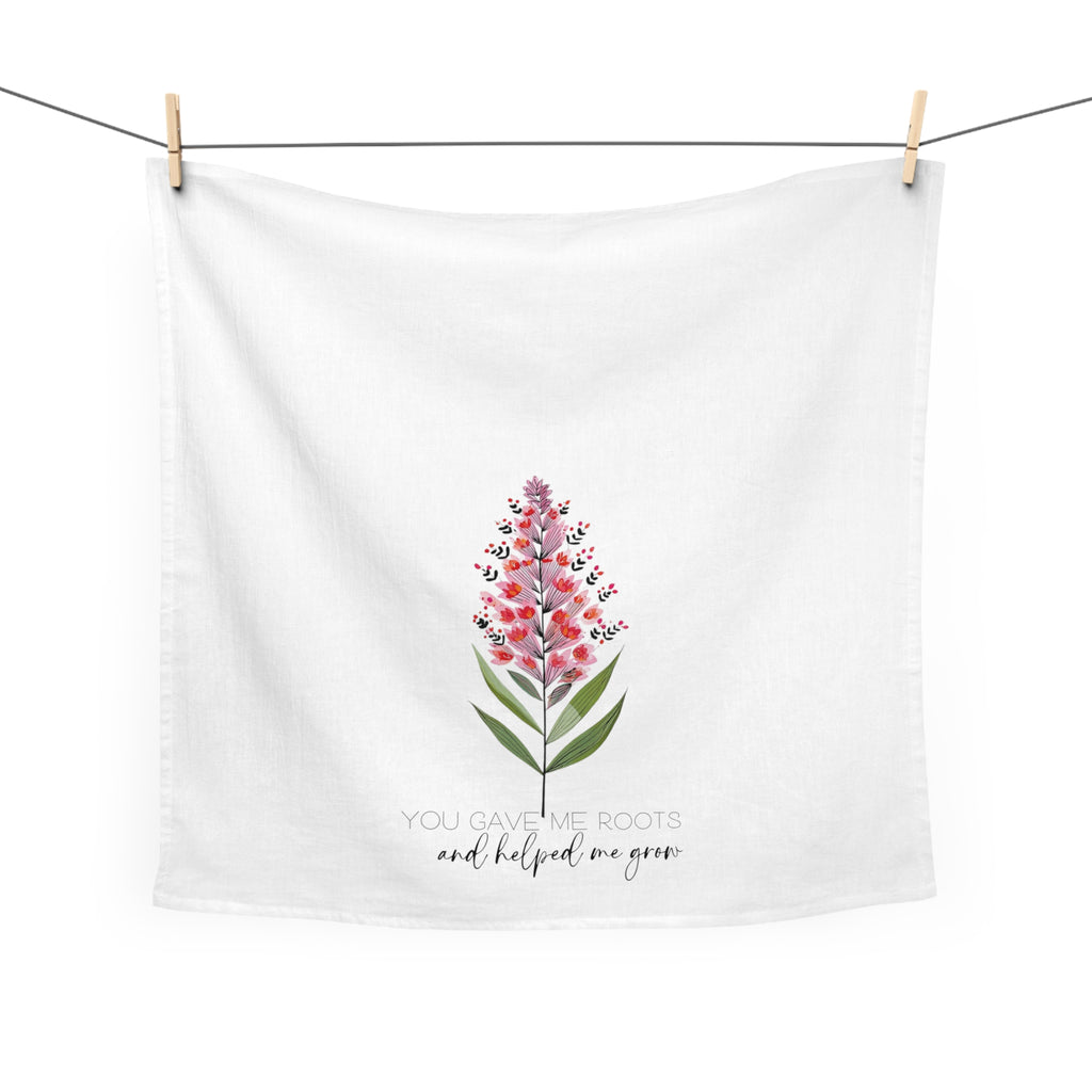 White towel with floral design and text hanging on a line
