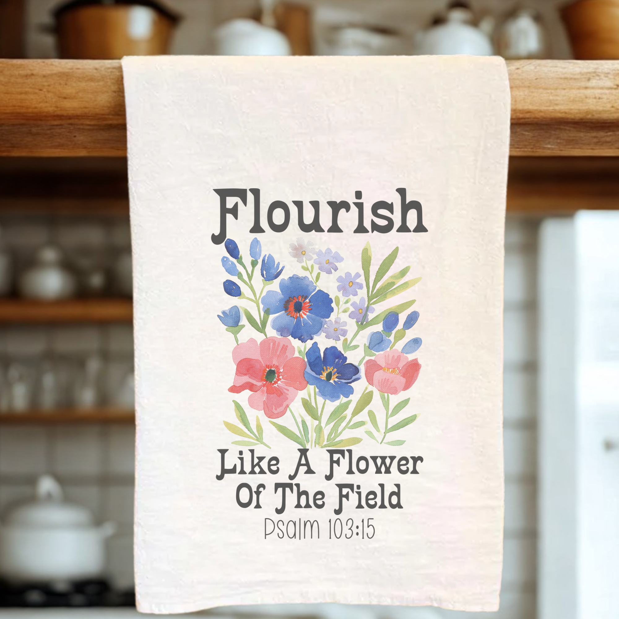 White tea towel with floral design and text on a kitchen rack