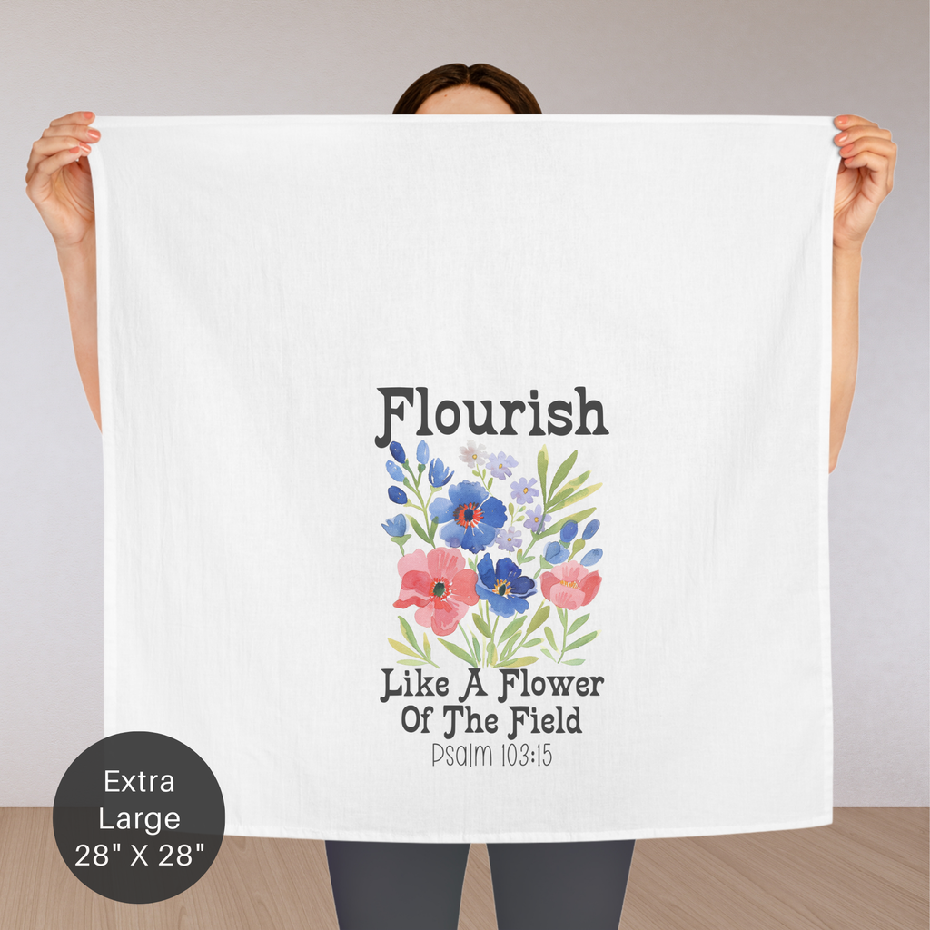 Person holding an extra large white tea towel with floral design and text.