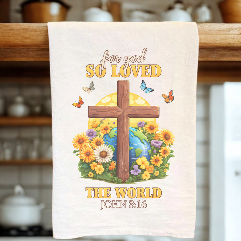 Decorative towel with cross, flowers, and world map design, hanging on a wooden rack.
