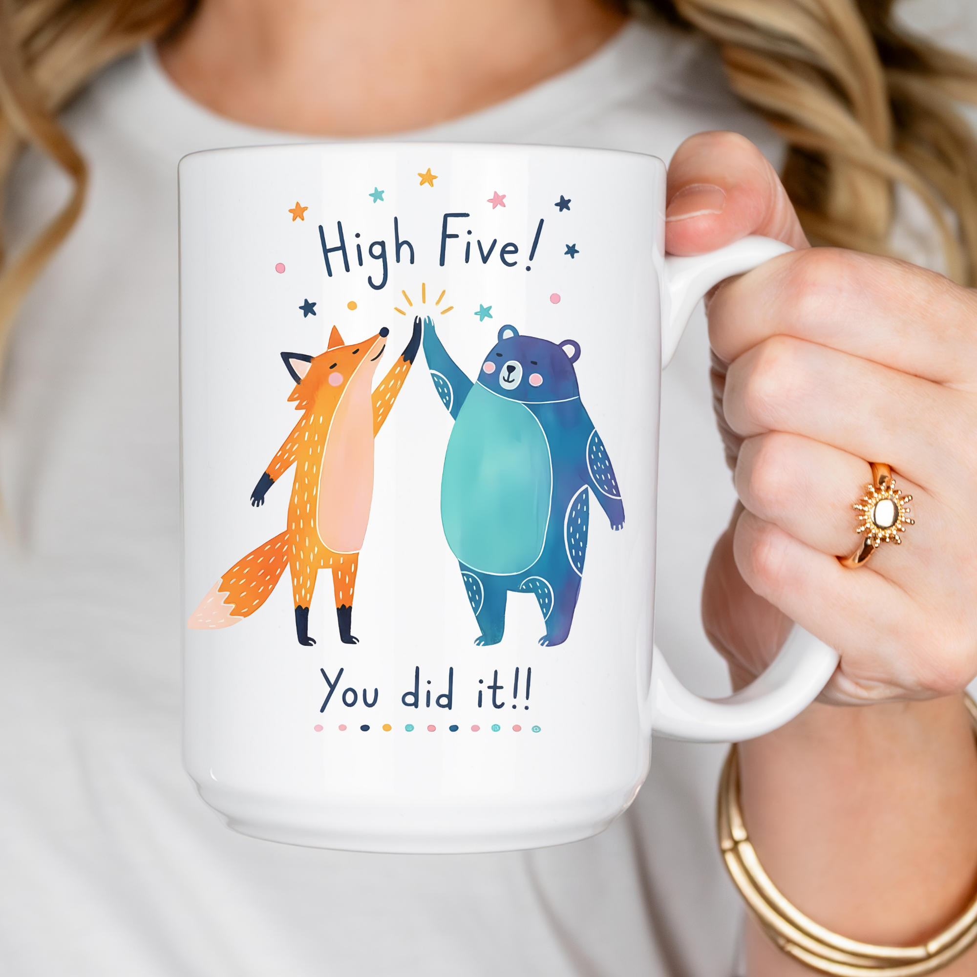 Person holding a mug with a fox and bear design and text 'High Five! You did it!!'