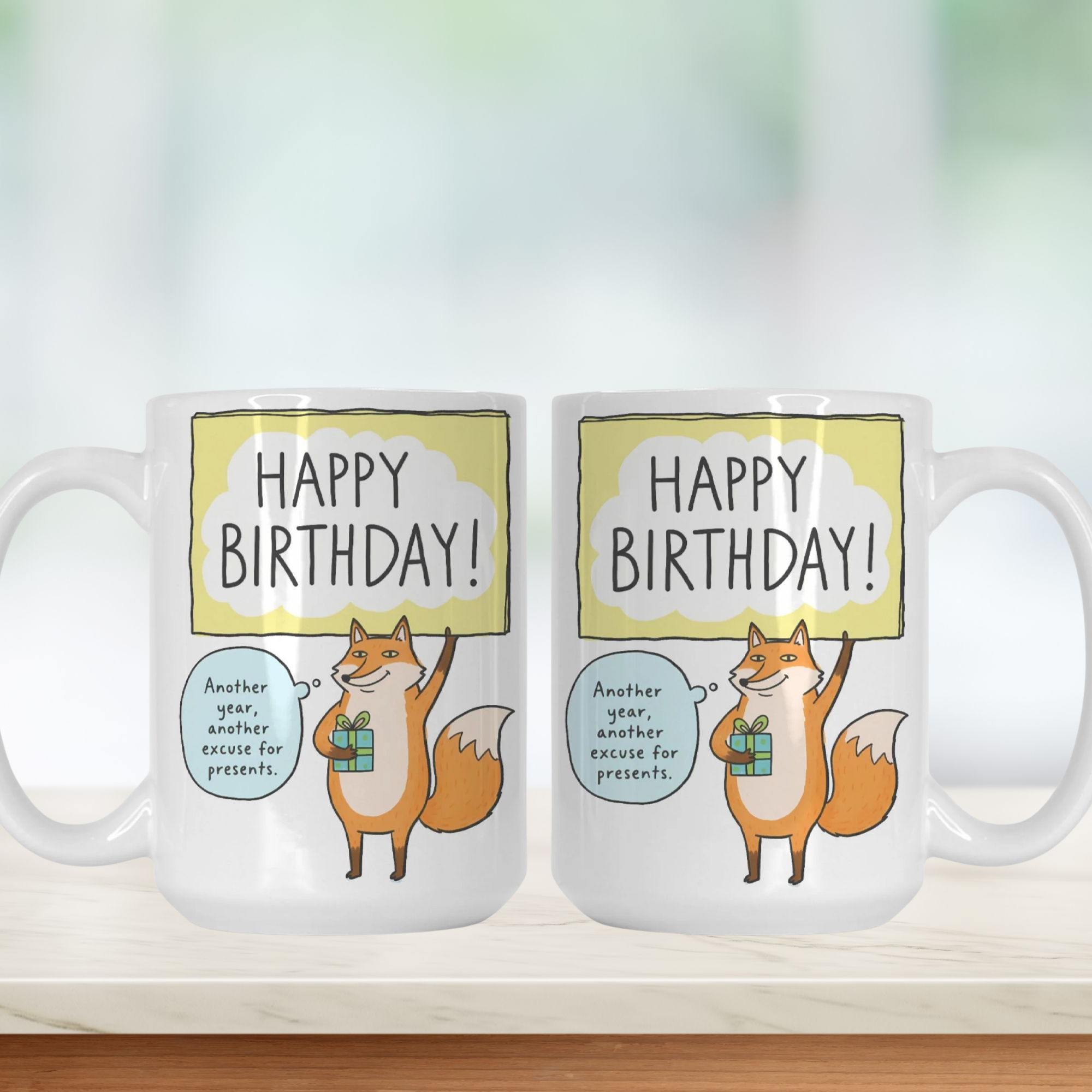 Two mugs with fox illustrations and 'Happy Birthday!' text on a white background