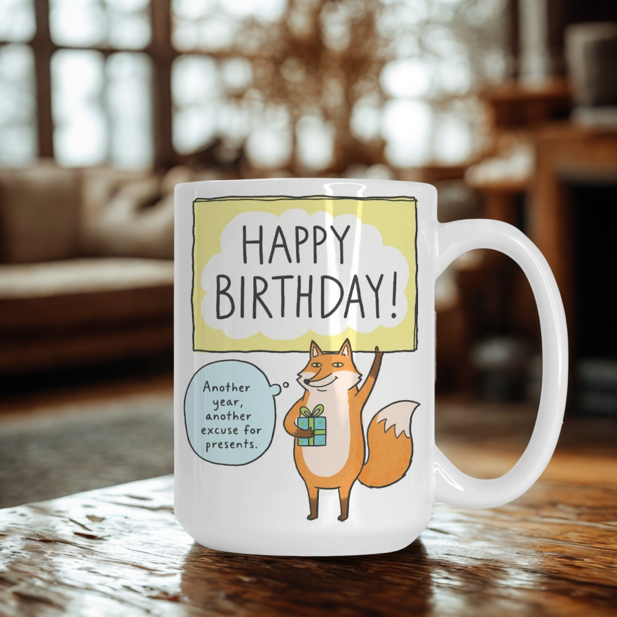 Mug with a fox illustration and 'Happy Birthday!' text on a wooden table.
