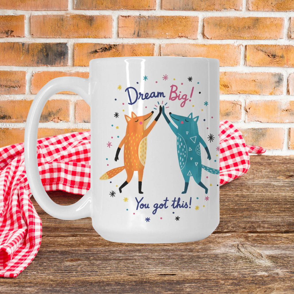 Mug with fox design and motivational text on a wooden picnic table with a brick wall background