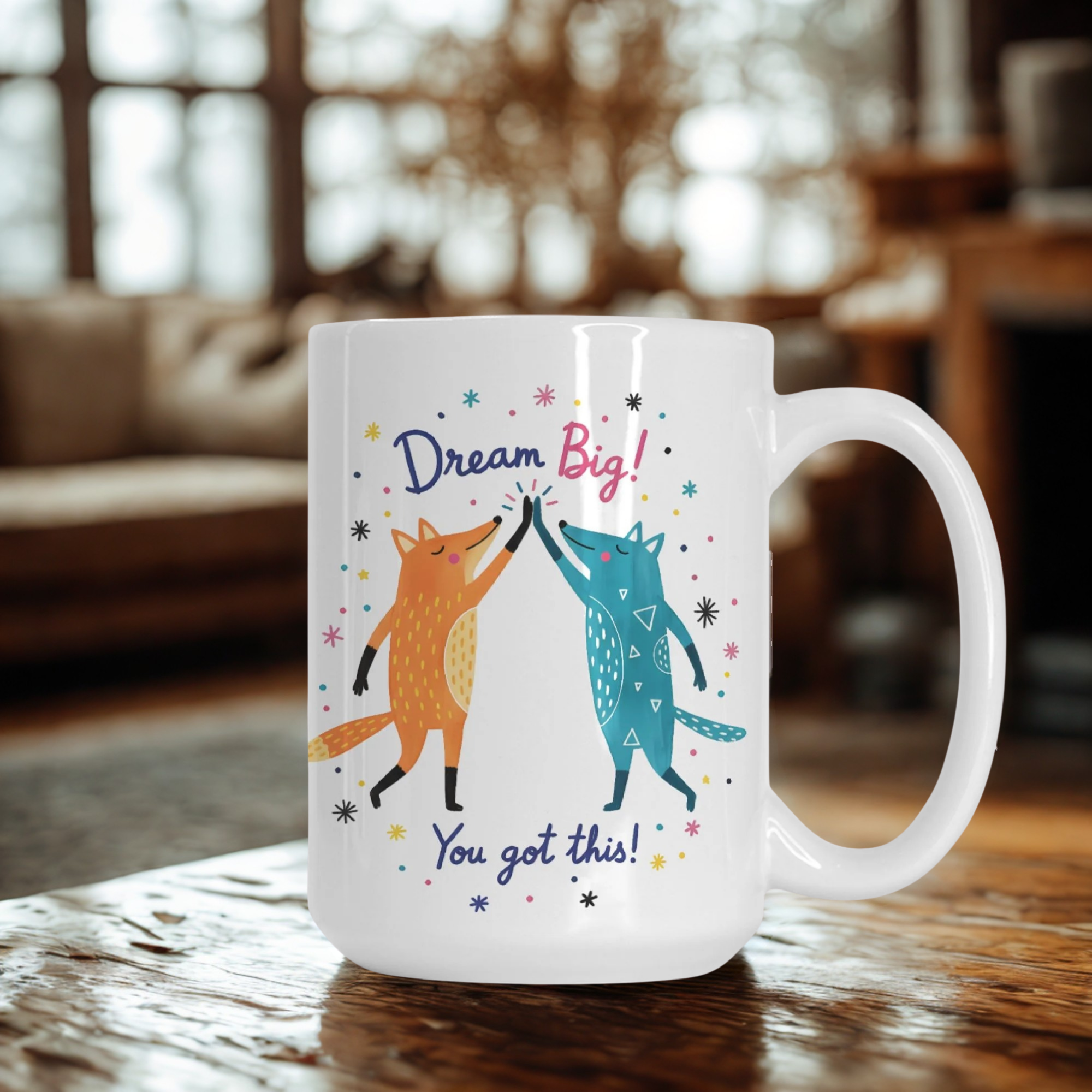 Mug with foxes giving high fives and motivational text on a wooden table.