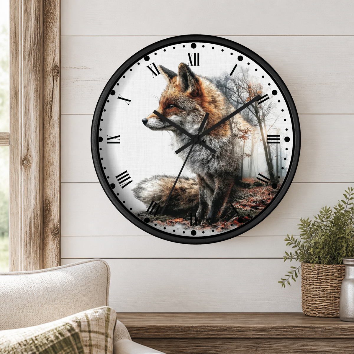 A round wall clock with a black frame and a printed fox illustration on the face, mounted on a white shiplap wall above a wooden console table with a plant and part of a chair visible.