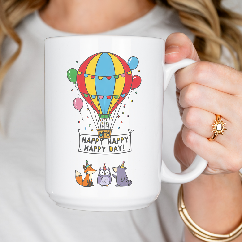 Person holding a mug with a colorful hot air balloon design and 'Happy Happy Happy Day!' text.