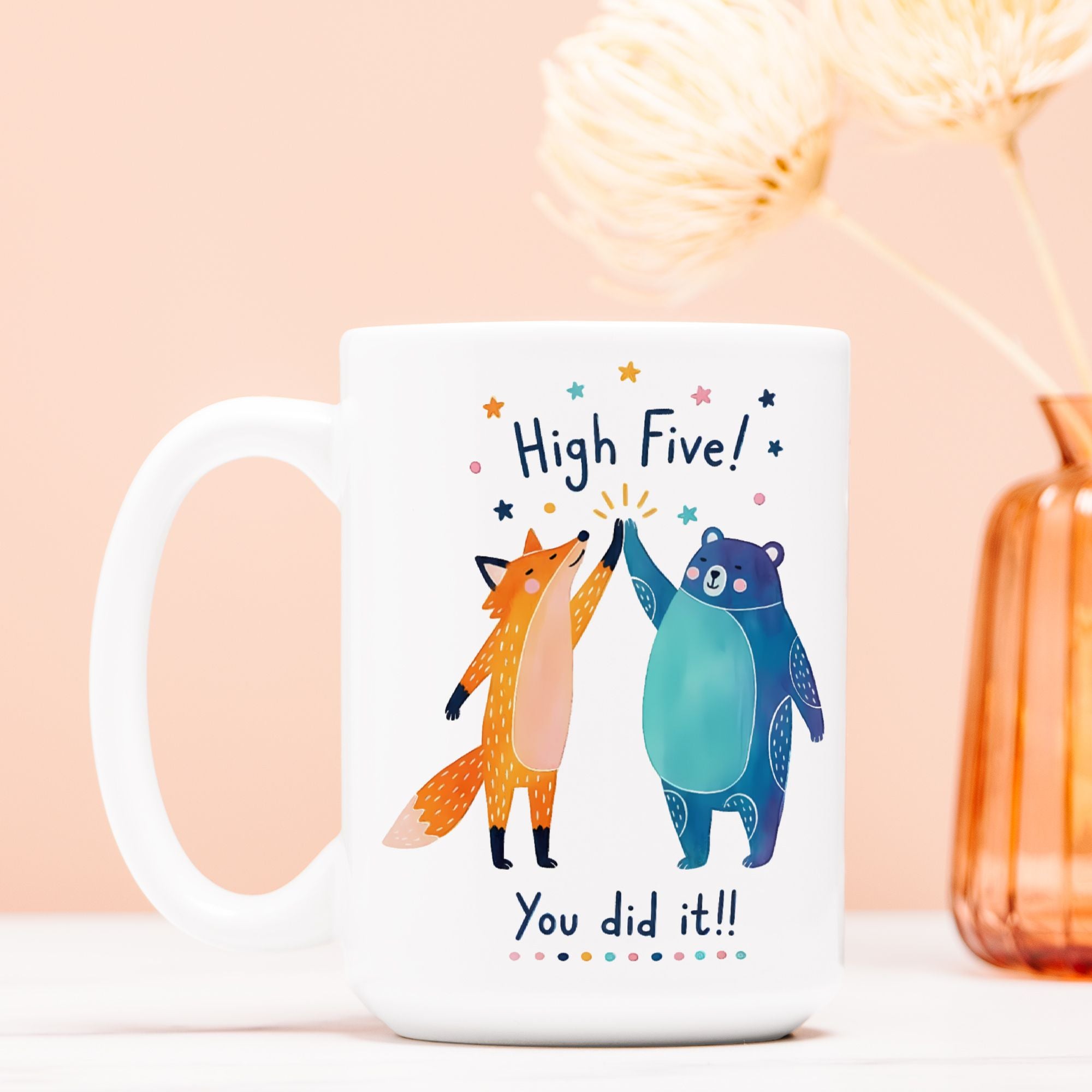 White mug with a fox and bear design and text on a light pink background