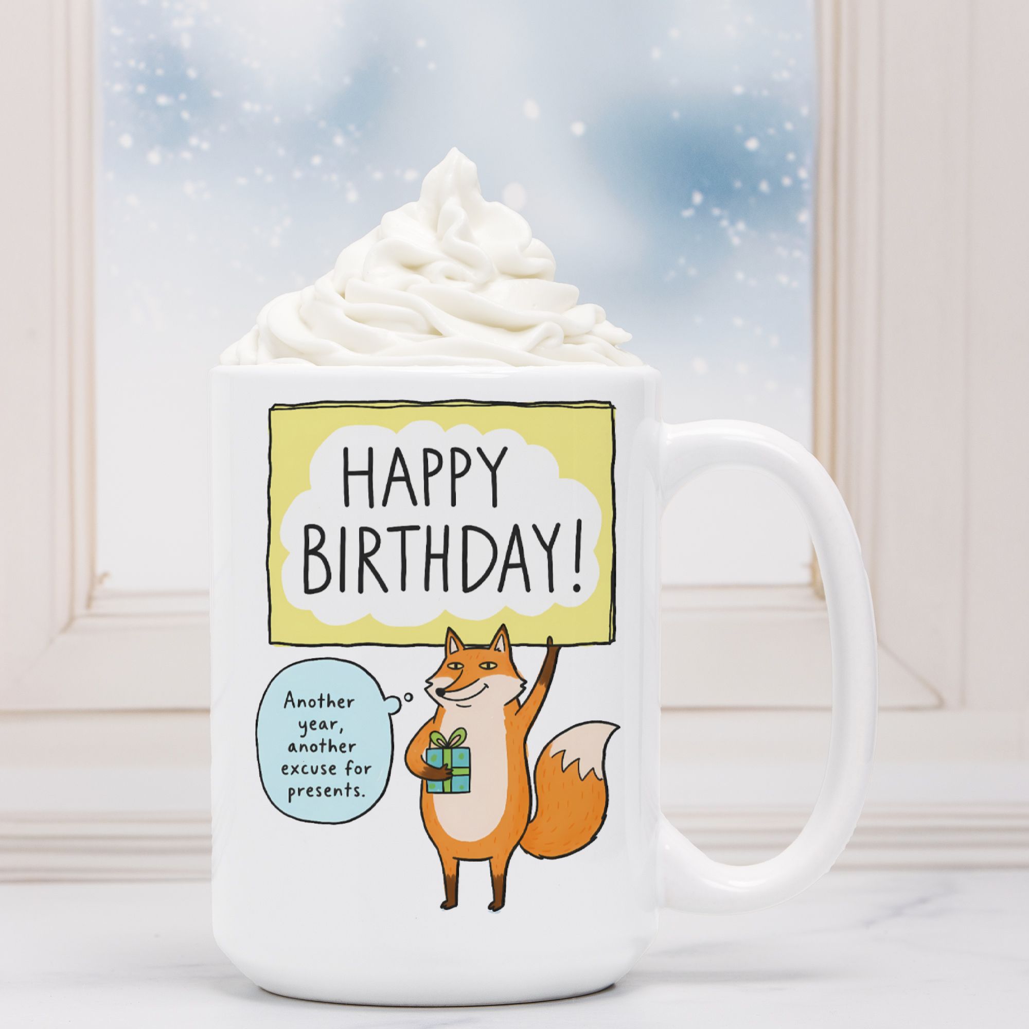 White mug with a fox illustration and 'Happy Birthday!' text against a snowy window background