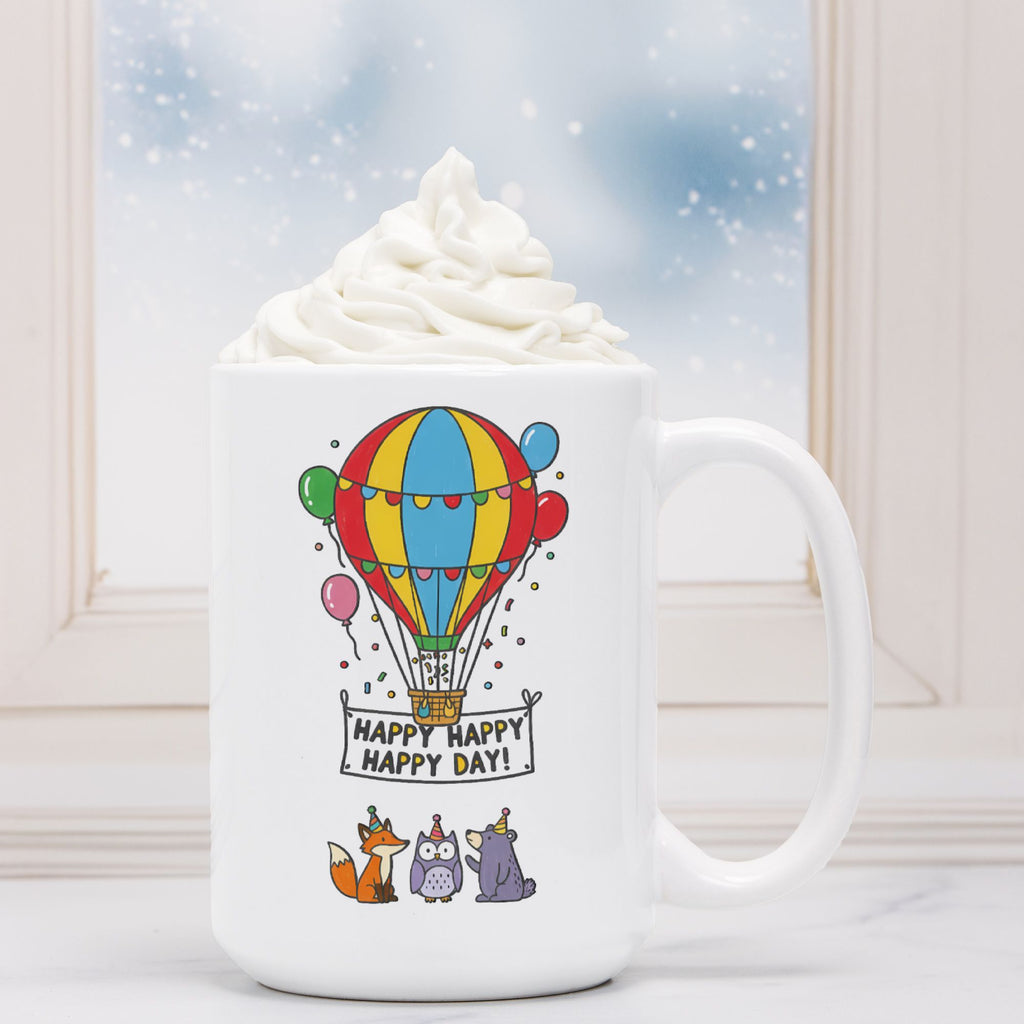 White mug with a colorful hot air balloon design and 'Happy Happy Happy Day' text, filled with hot chocolate.