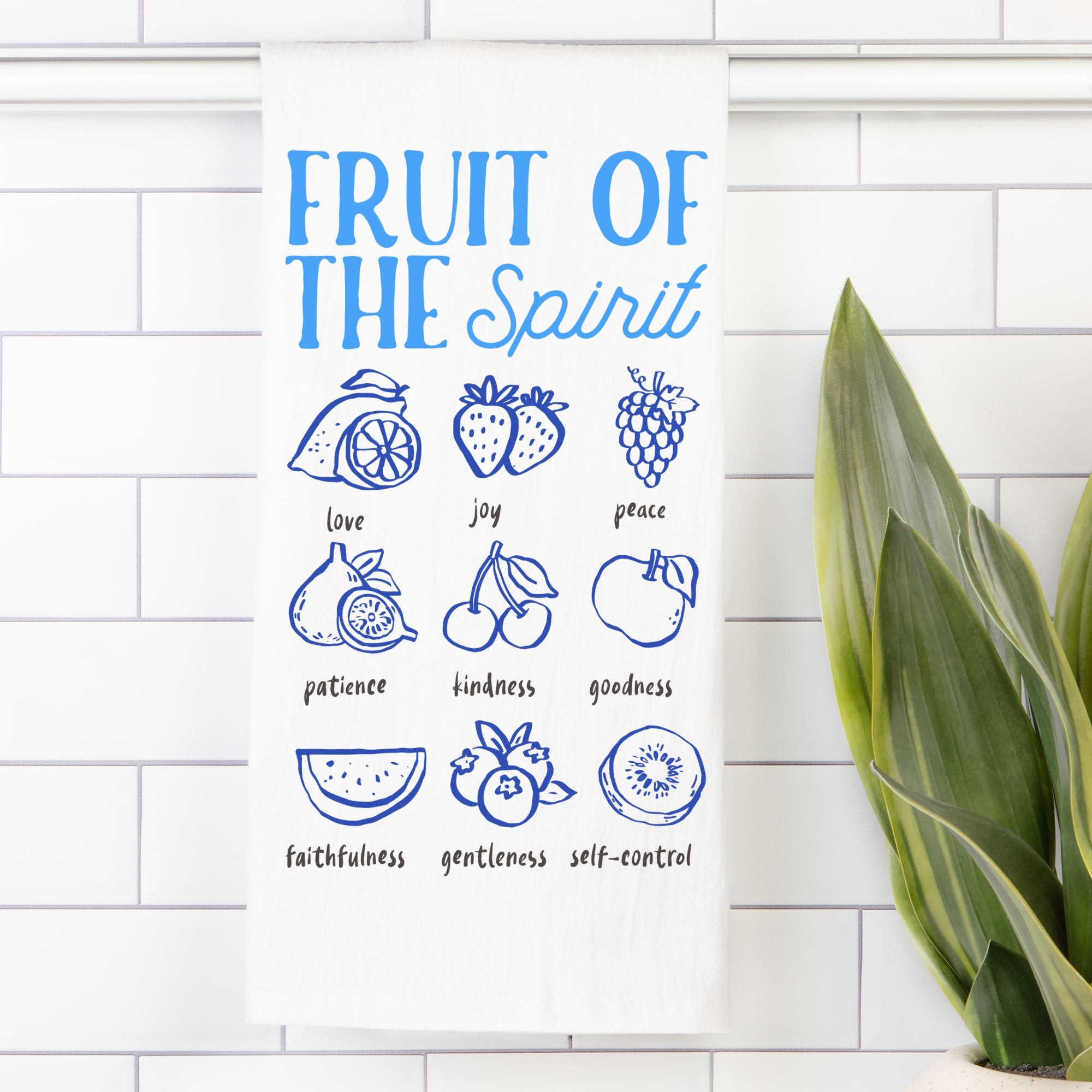 Tea towel with Illustrations of the 'Fruit of the Spirit' with corresponding fruits on a white tiled wall.
