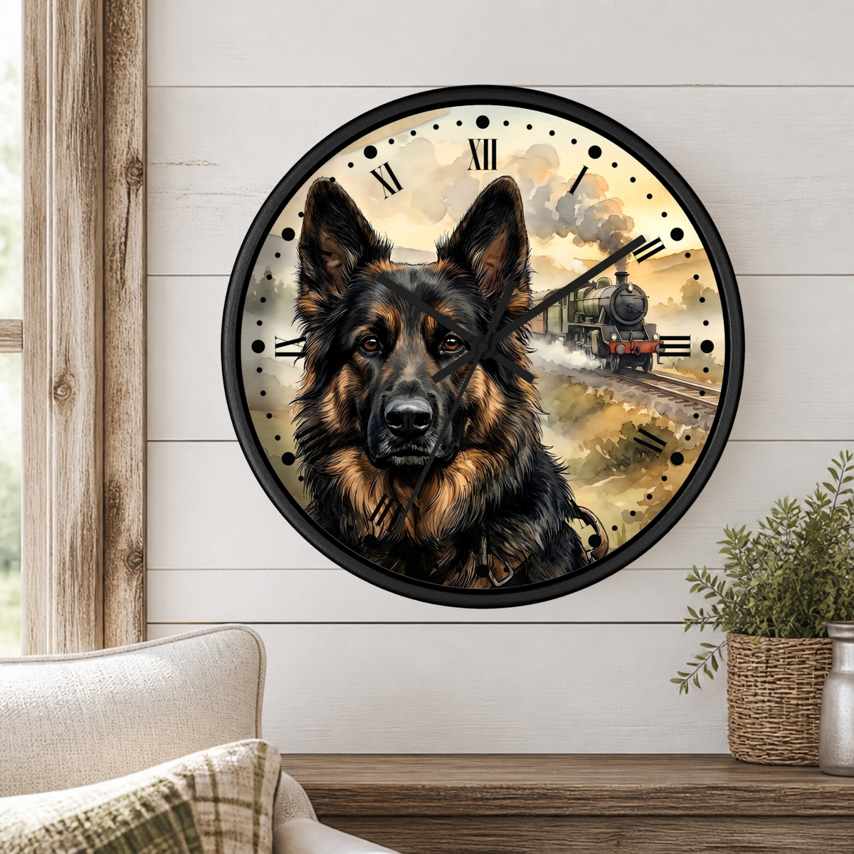 A round wall clock with a black frame and a printed illustration of a German Shepherd dog over a vintage train scene, mounted on a white wood-paneled wall above a wooden table with a plant and part of a chair visible.