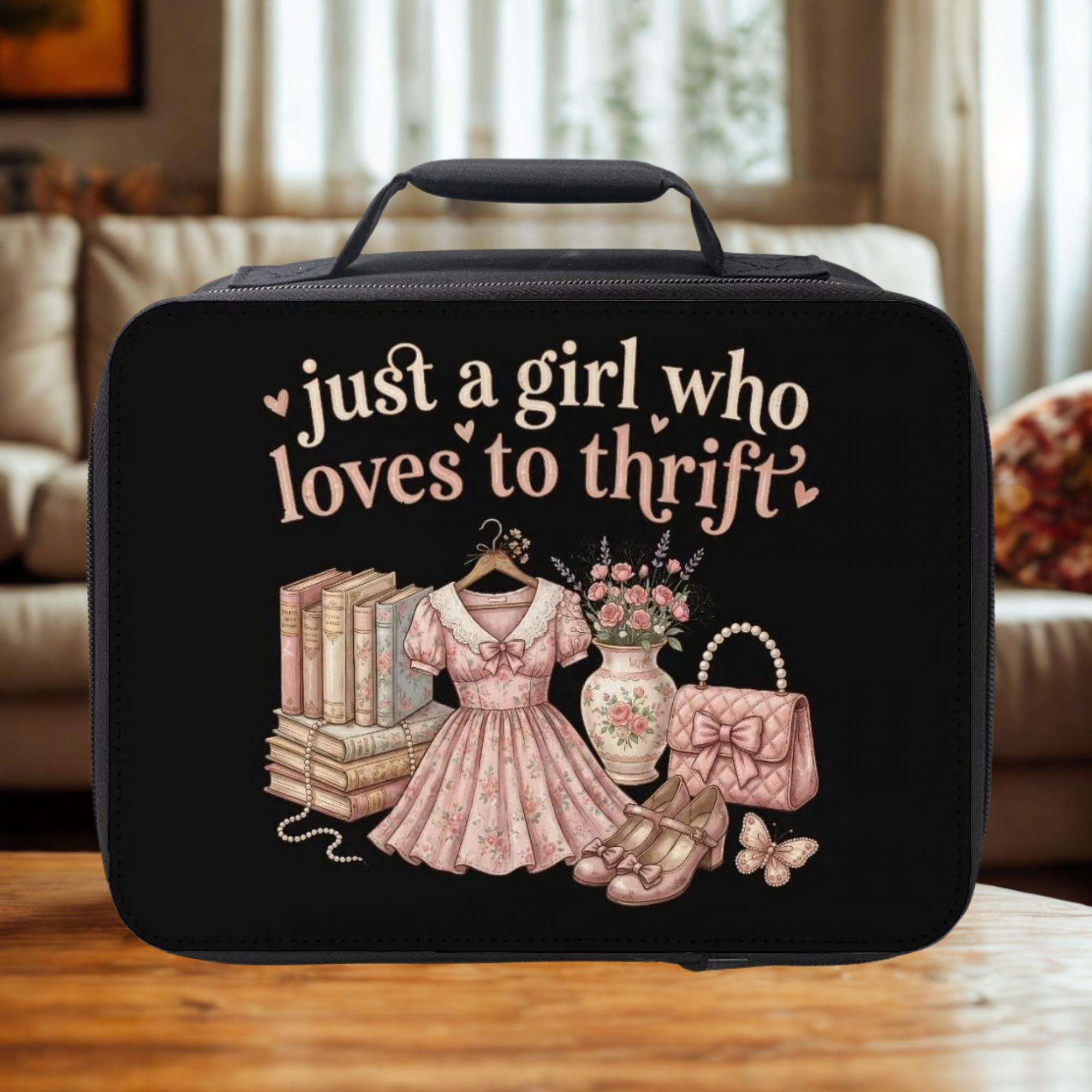 Black lunch bag with 'just a girl who loves to thrift' text and vintage illustrations on a wooden surface.