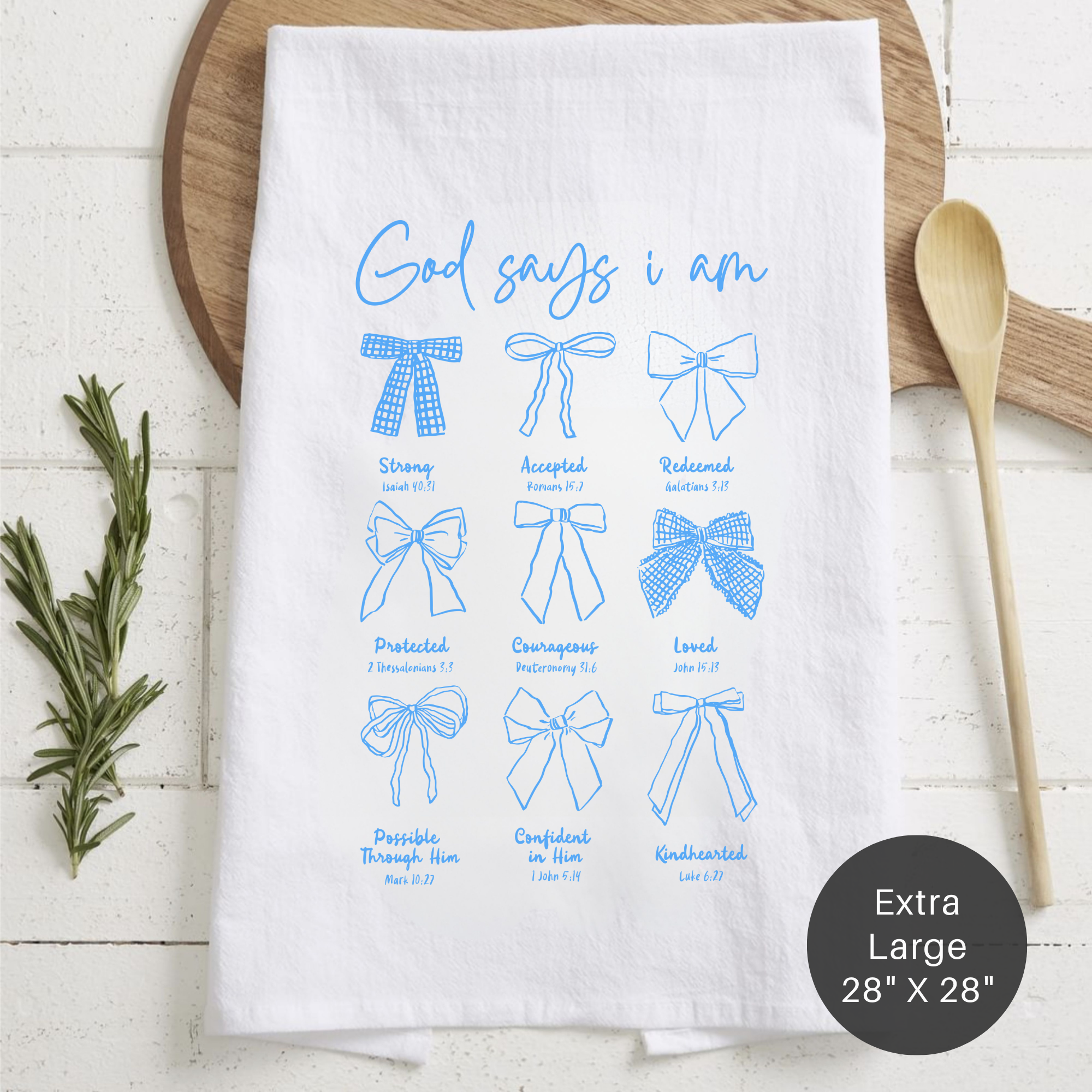 White tea towel with blue text and bows on a wooden surface