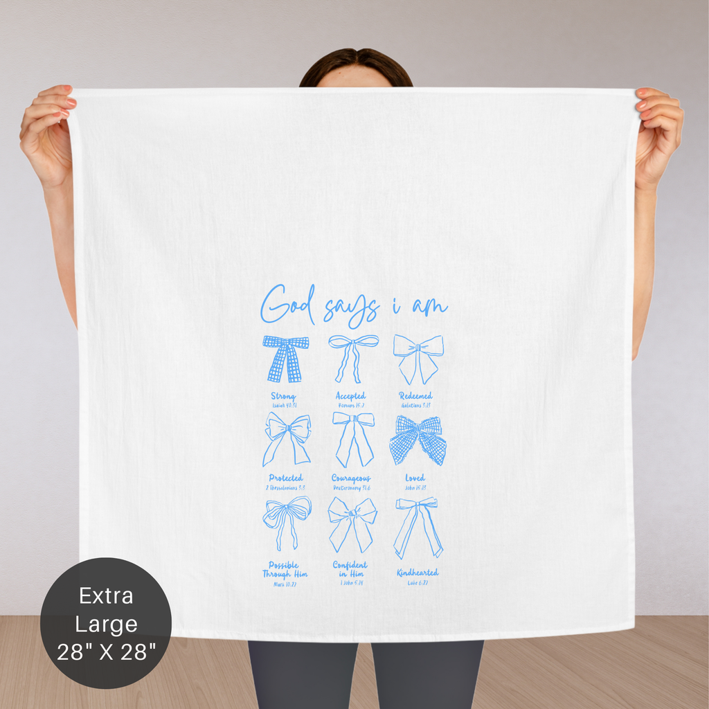 Person holding an extra large white tea towel with blue text and graphics on a plain background