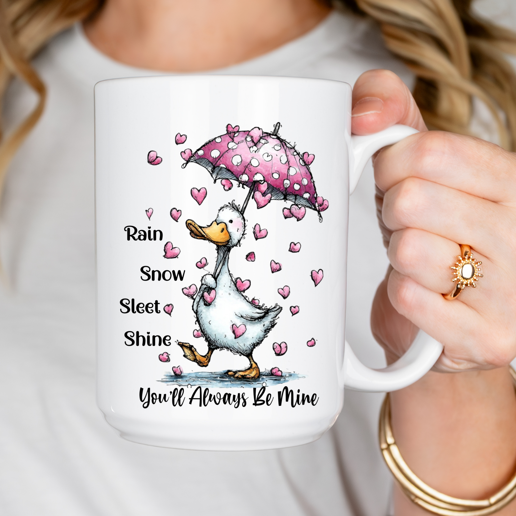 Mug with a cartoon goose holding a pink umbrella and heart pattern, held by a person.