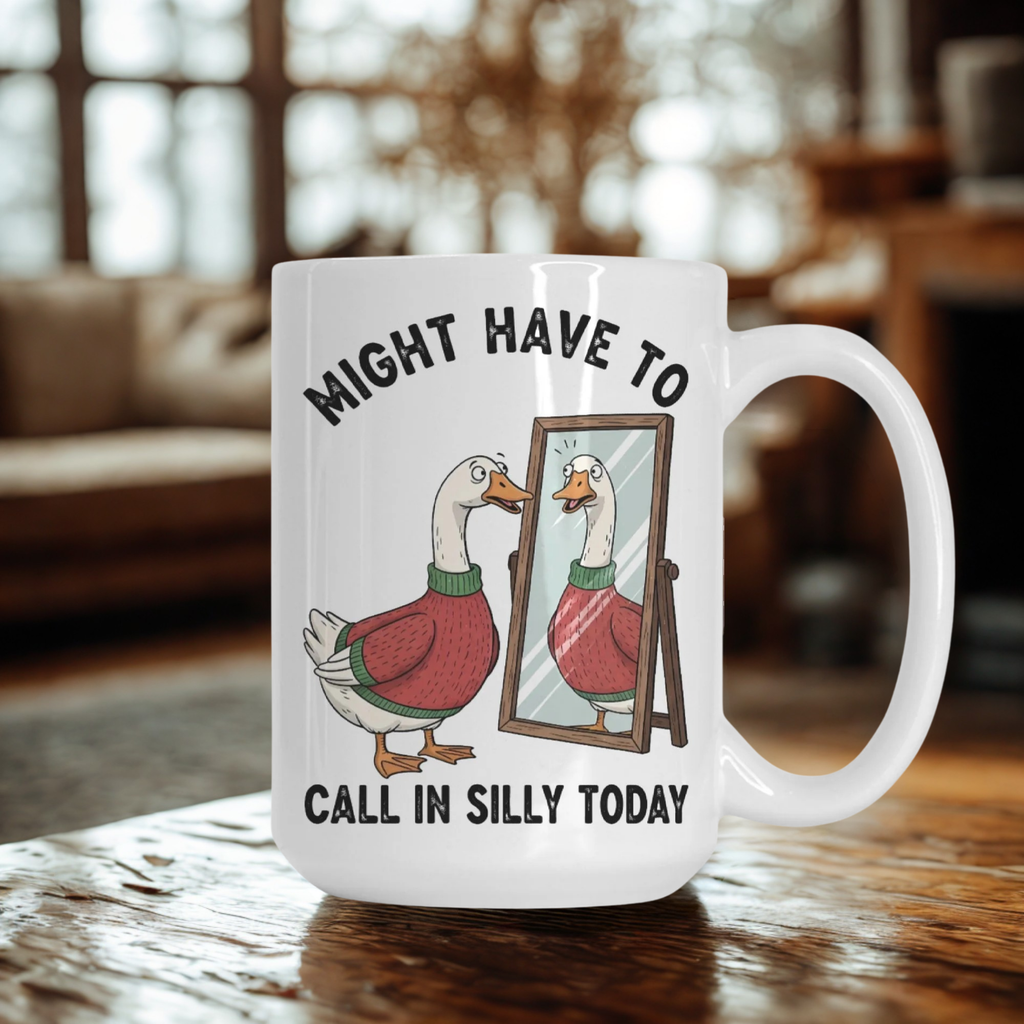 White mug with cartoon goose looking in the mirror and text 'Might Have To Call In Silly Today' on a wooden table
