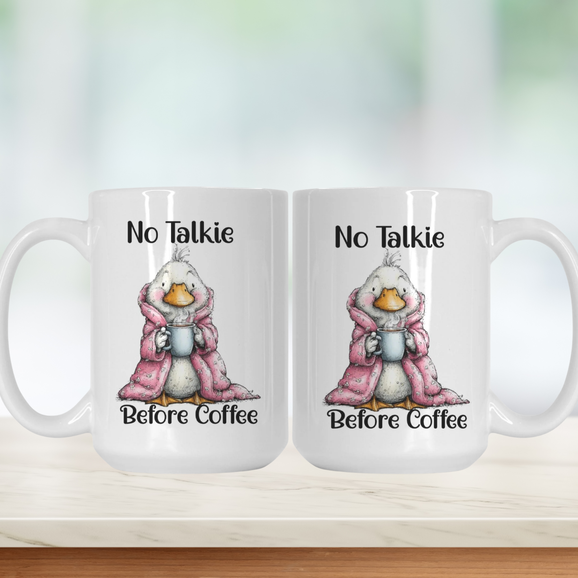 Two white mugs with a cartoon goose in a pink robe and text 'No Talkie Before Coffee' on a white background.