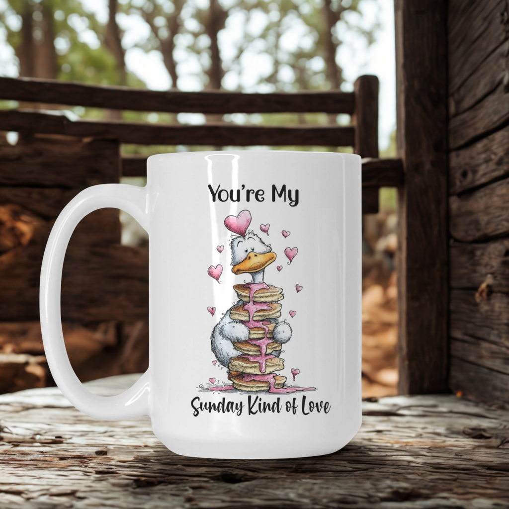 White mug with a cartoon goose design and text ' You're My Sunday Kind of Love' on a wooden surface outdoors