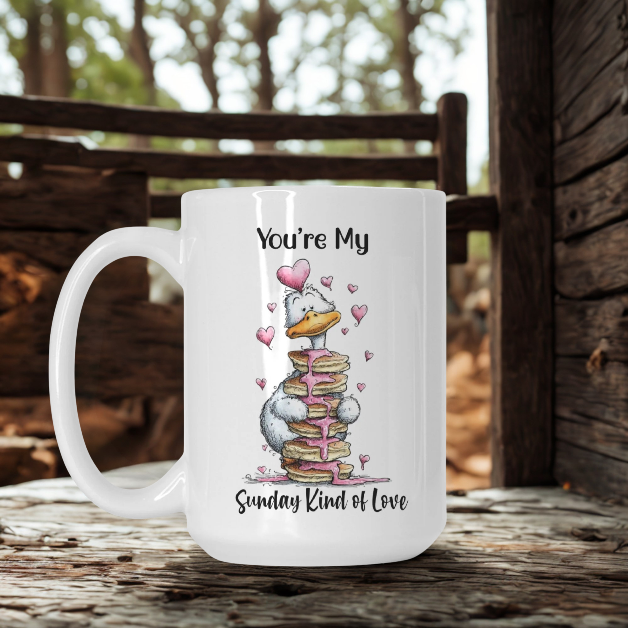 White mug with a cartoon goose design and text ' You're My Sunday Kind of Love' on a wooden surface outdoors