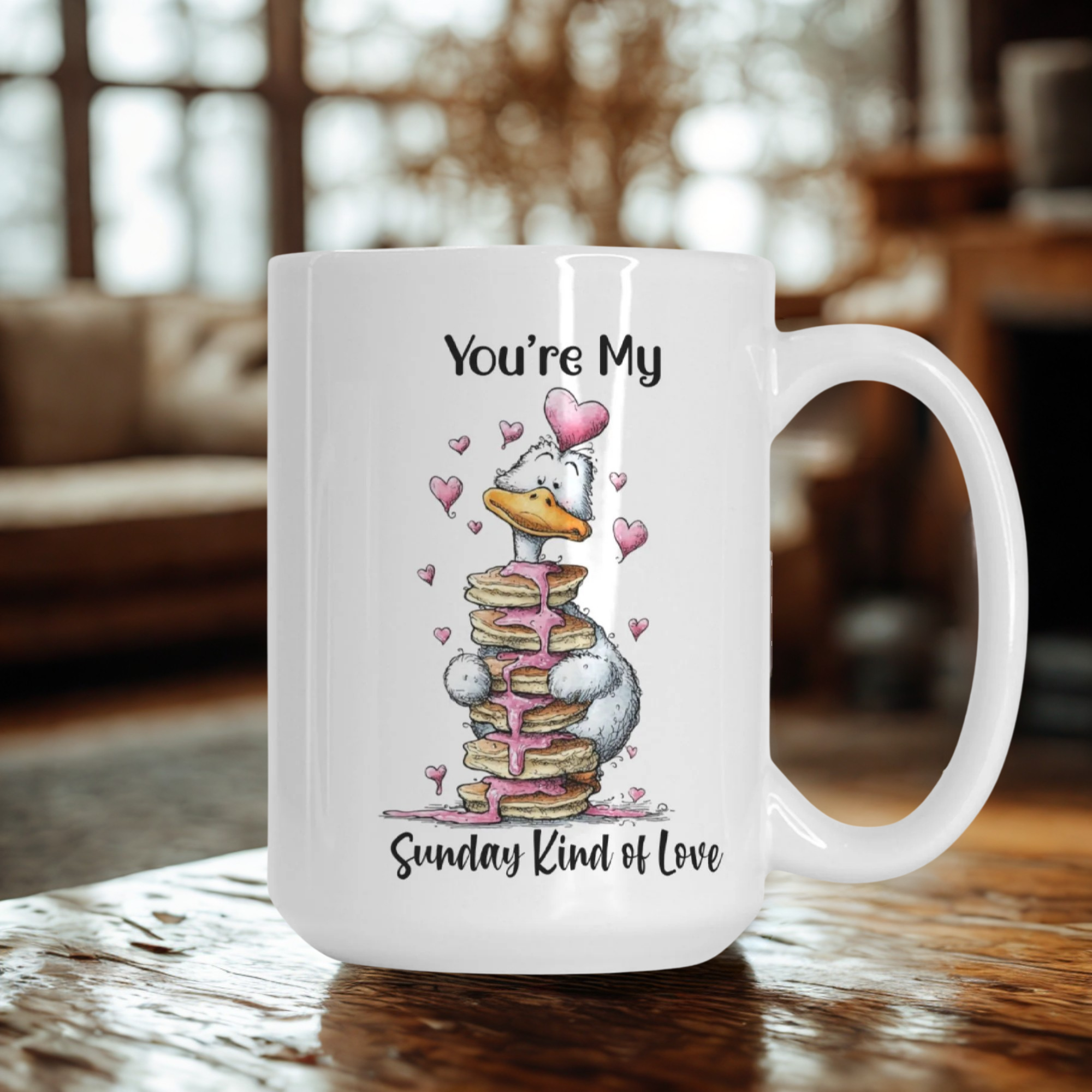 White mug with a cartoon goose and text 'You're My Sunday Kind of Love' on a wooden table