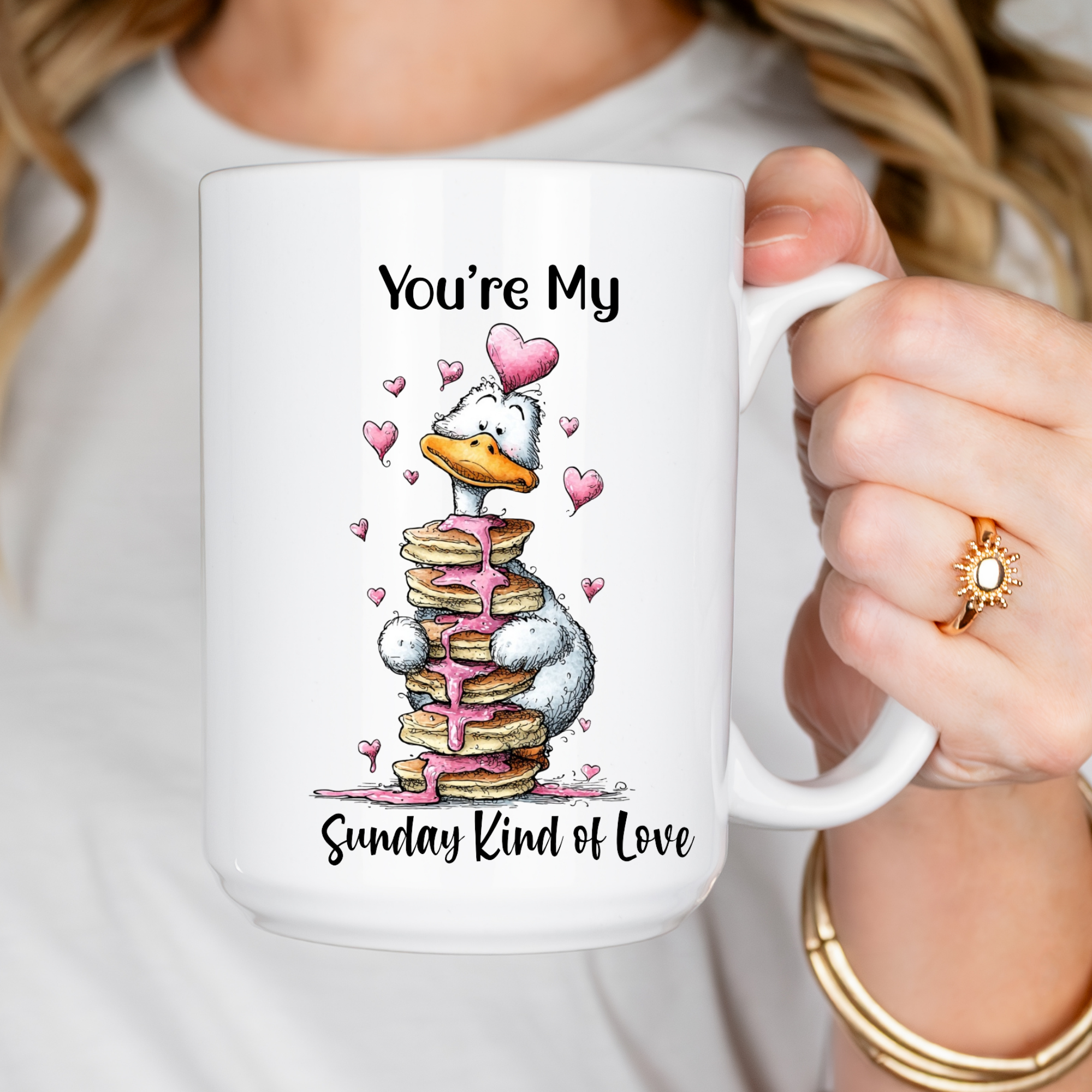 Person holding a mug with a cartoon character goose and romantic text design.