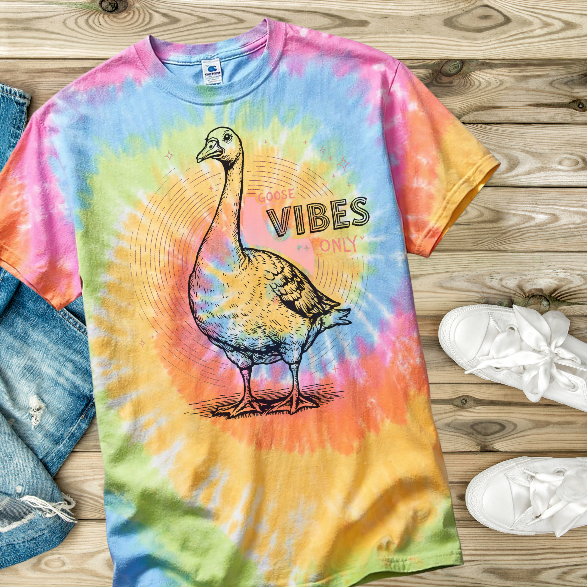 Colorful tie-dye t-shirt with a goose graphic and 'Goose Vibes Only' text on a wooden surface.
