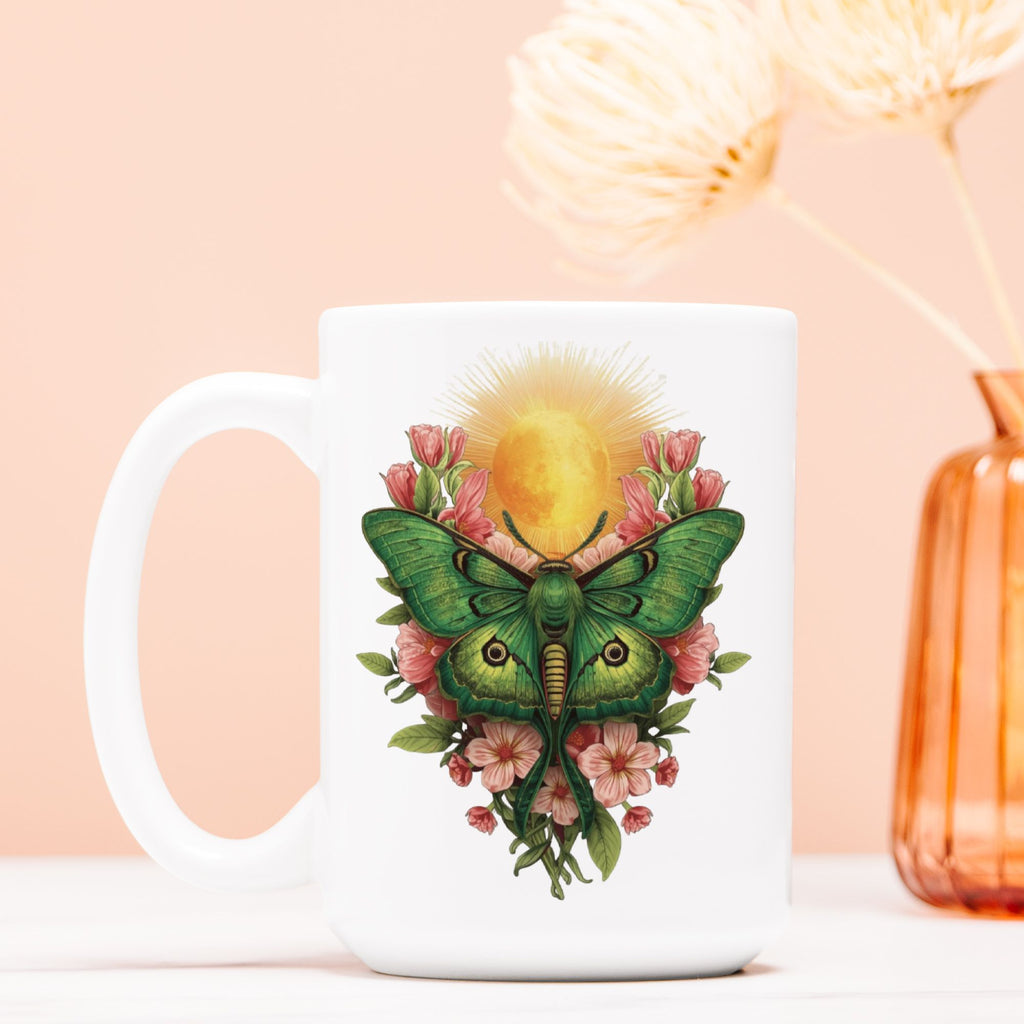 White mug with a green lunar moth and floral design on a peach background