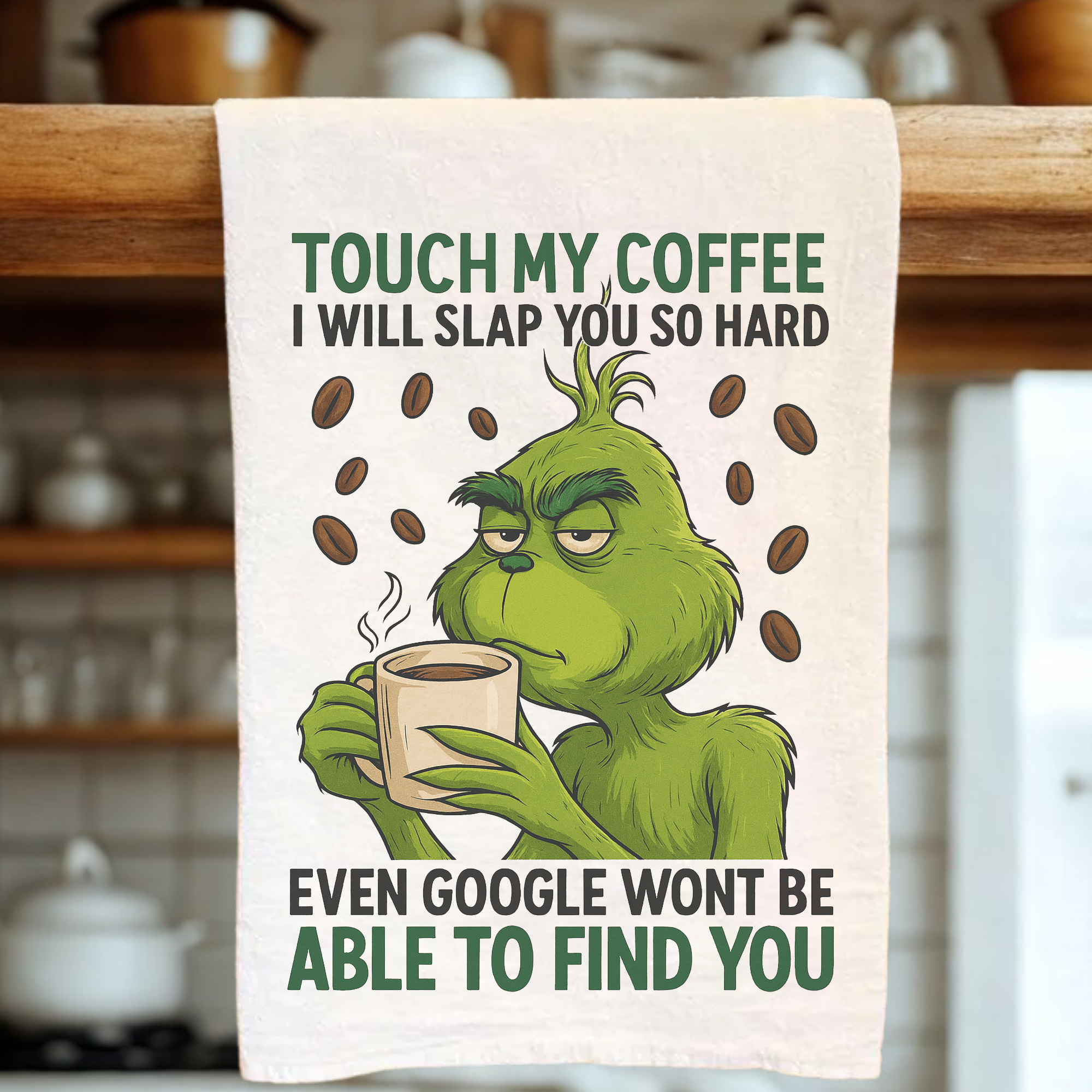 Tea towel with Grinch holding a coffee cup and text about coffee in a kitchen setting
