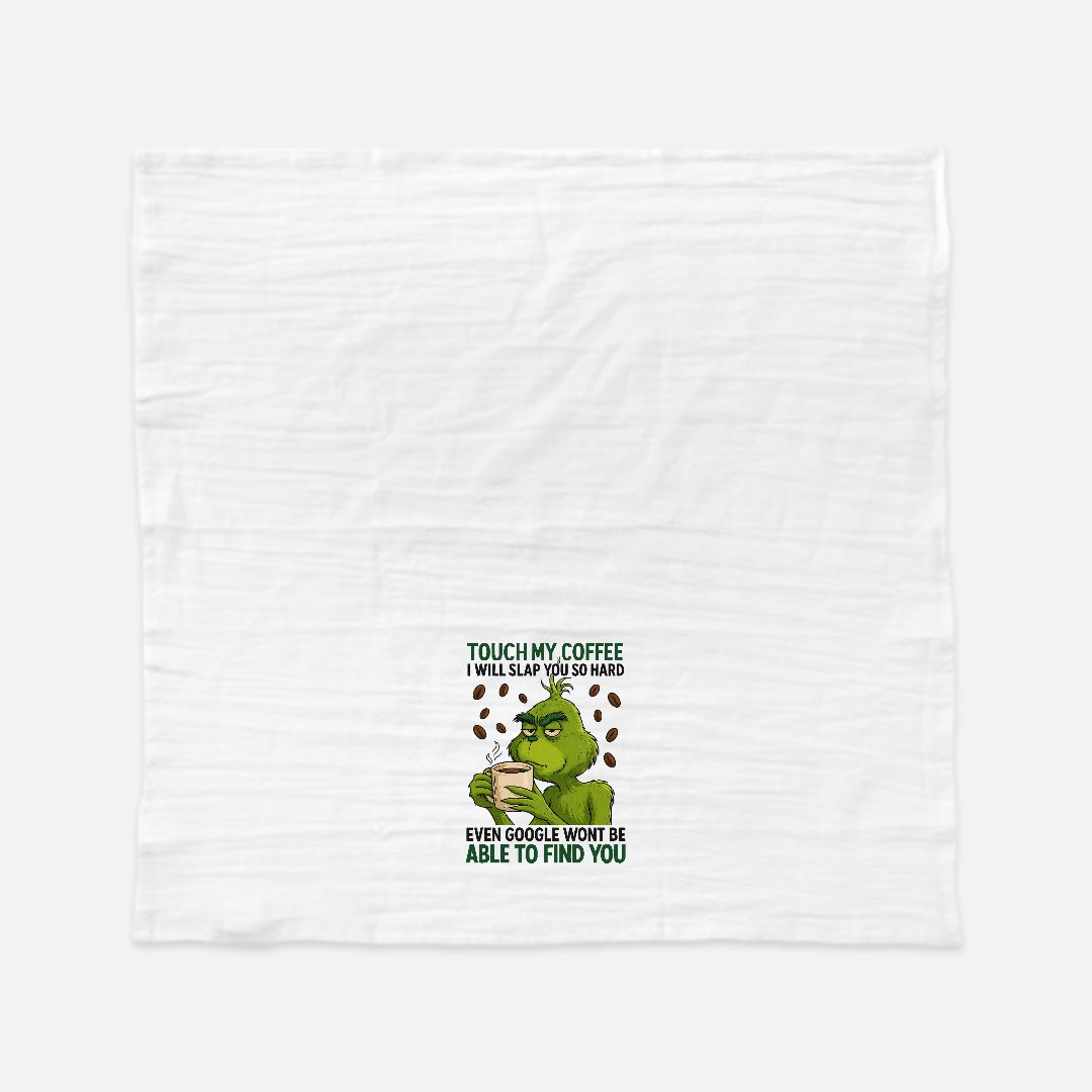 White tea towel with a green grinch holding a coffee cup and text on a white background