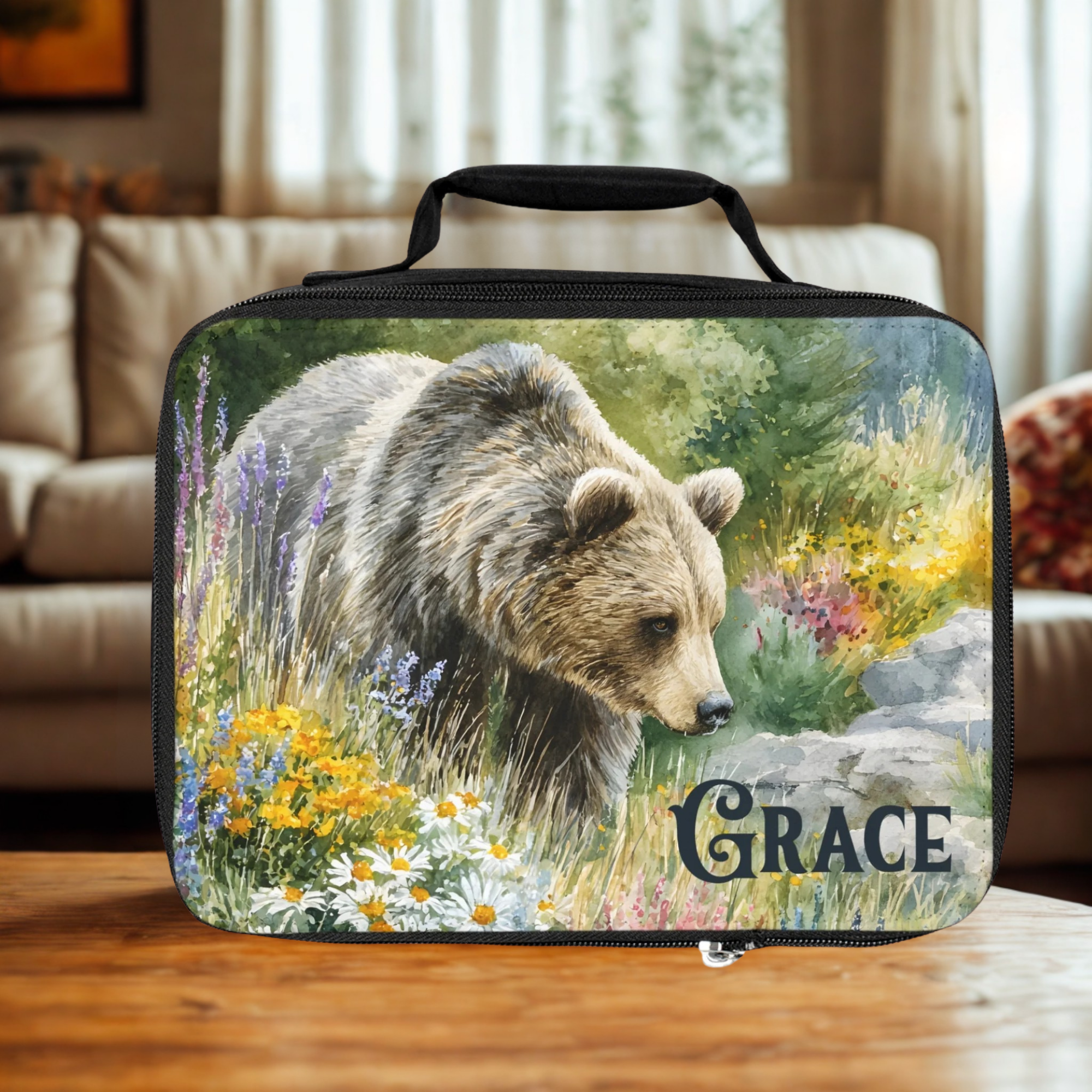  insulated lunch bag with bear design and 'Grace' personalized text on a wooden living room table.