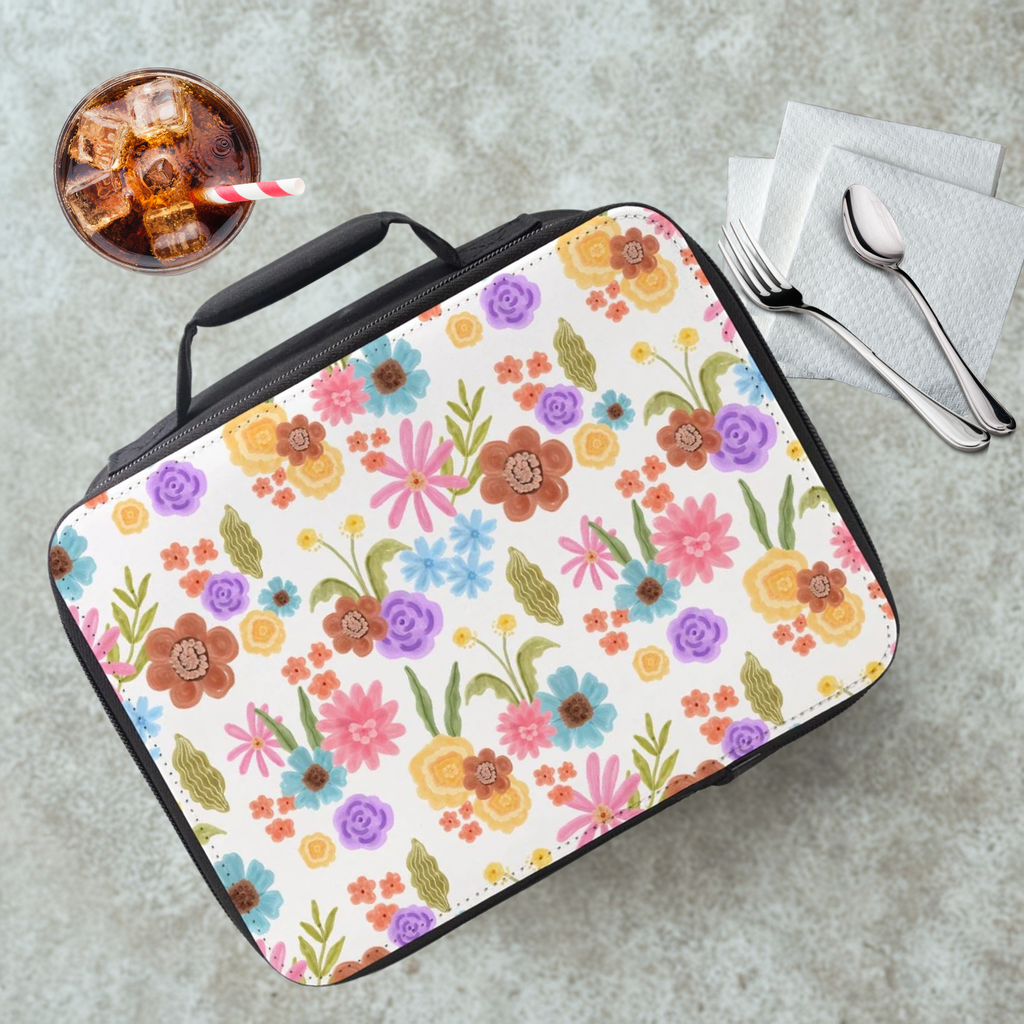 Floral-patterned lunch bag on a cafeteria table with a drink and utensils.