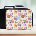 Floral-patterned lunch bag on a wooden surface with a blurred background