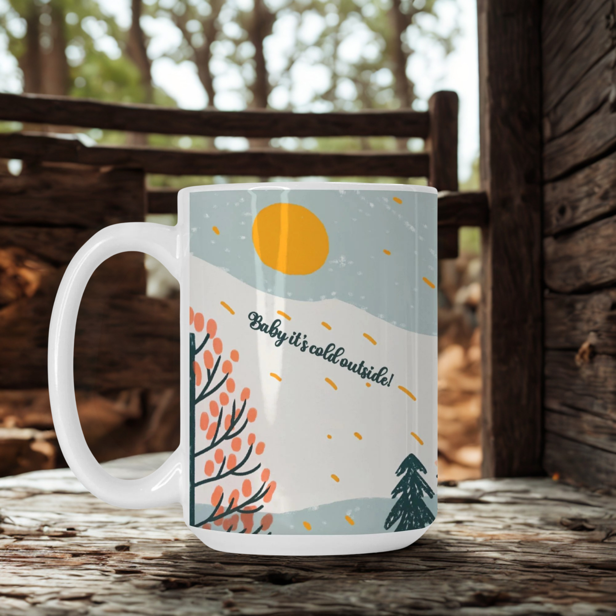 Mug with winter scene design and text 'Baby it's cold outside!' on a wooden surface.