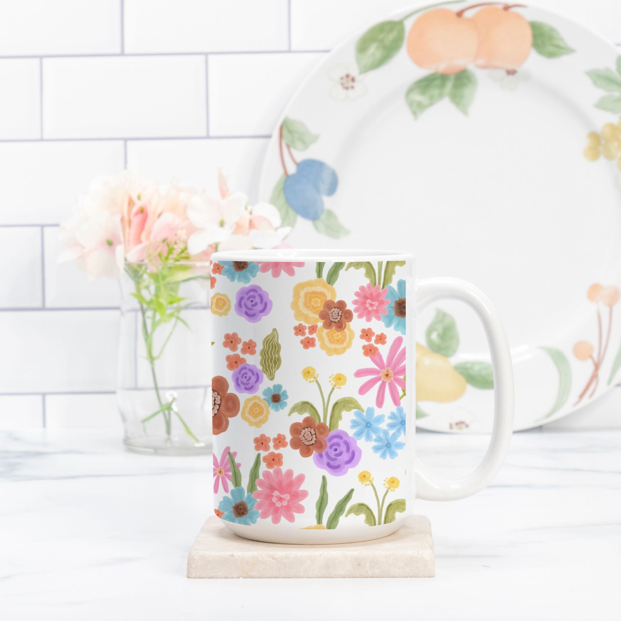 Floral mug and plate on a white surface with a tiled wall background