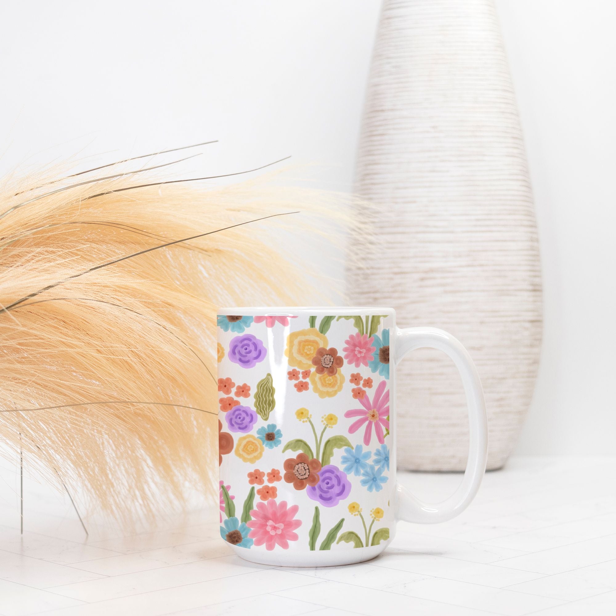 Floral-patterned mug on a white surface with a blurred background