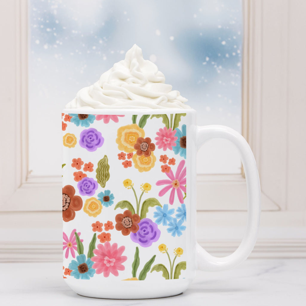 White mug with floral pattern filled with hot chocolate and whipped cream.