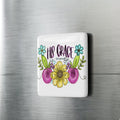 Decorative porcelain magnet with floral design and text on a refrigerator