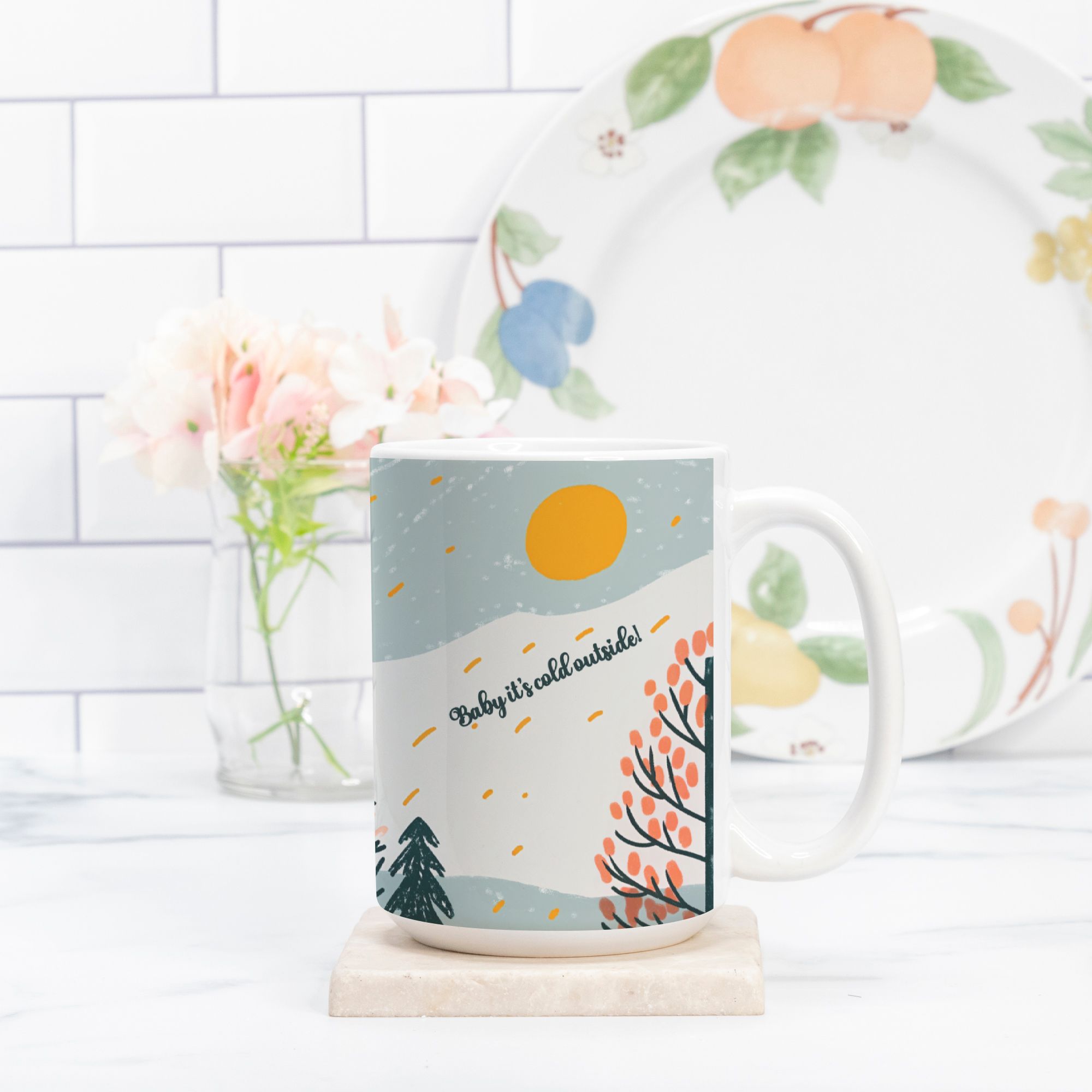 Mug with winter scene design and floral plate in the background