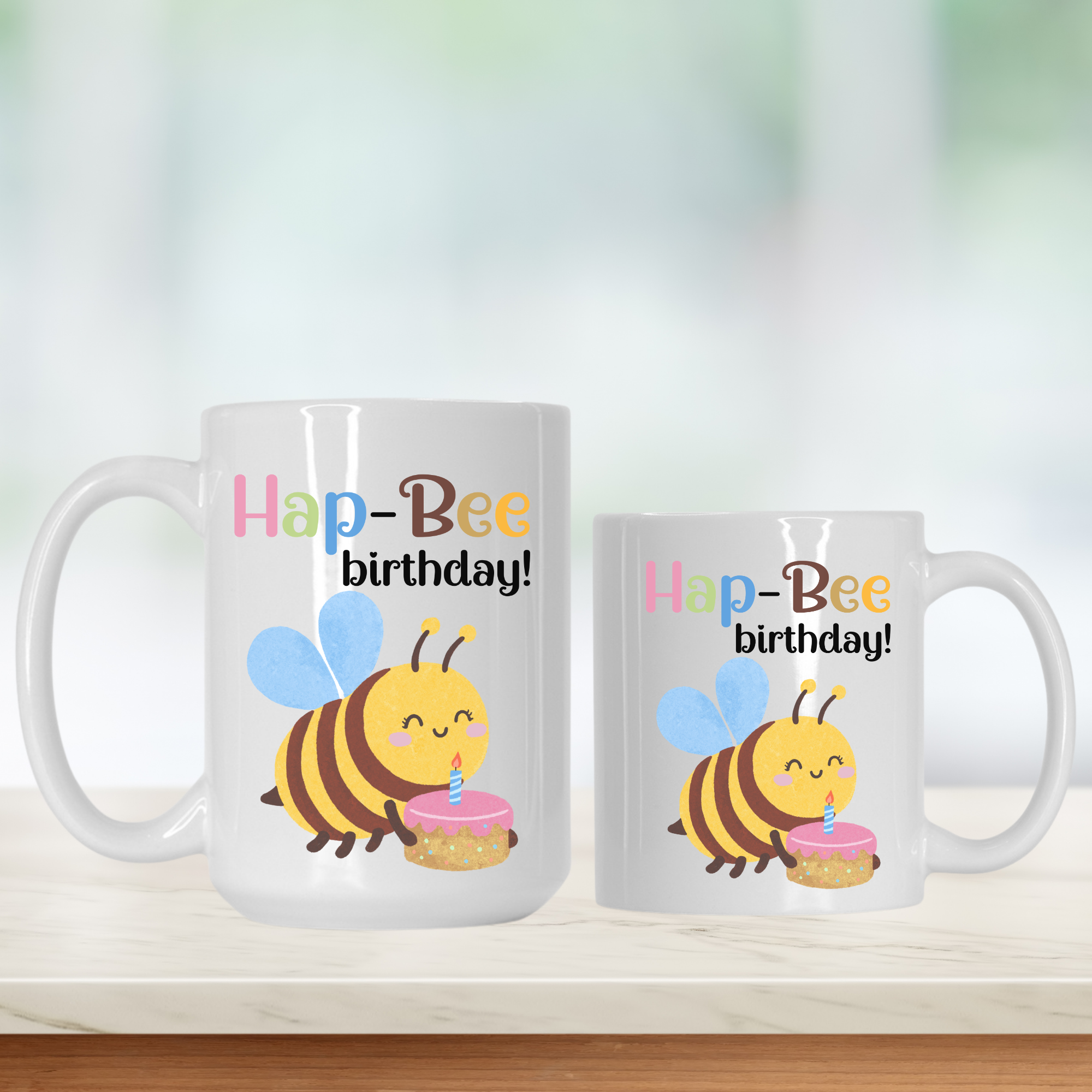 Two mugs with a bee design and 'Hap-Bee birthday!' text on a white background.