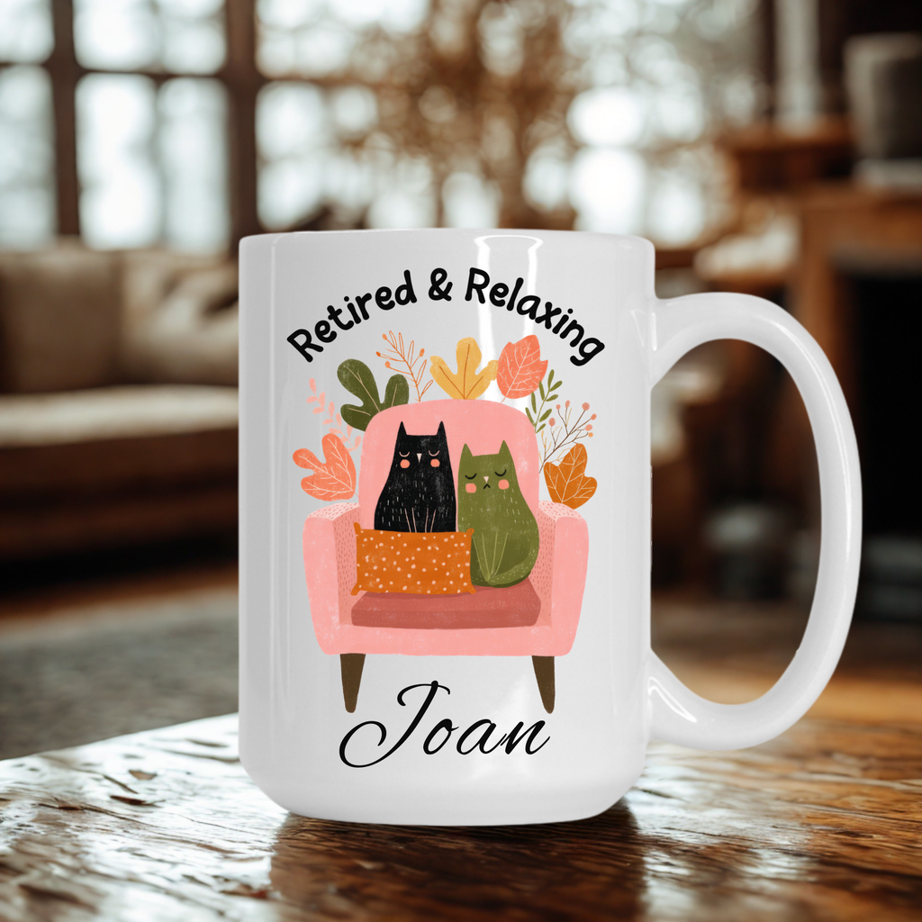 Mug with cartoon cats on a chair and text 'Retired & Relaxing Joan' in a home setting.