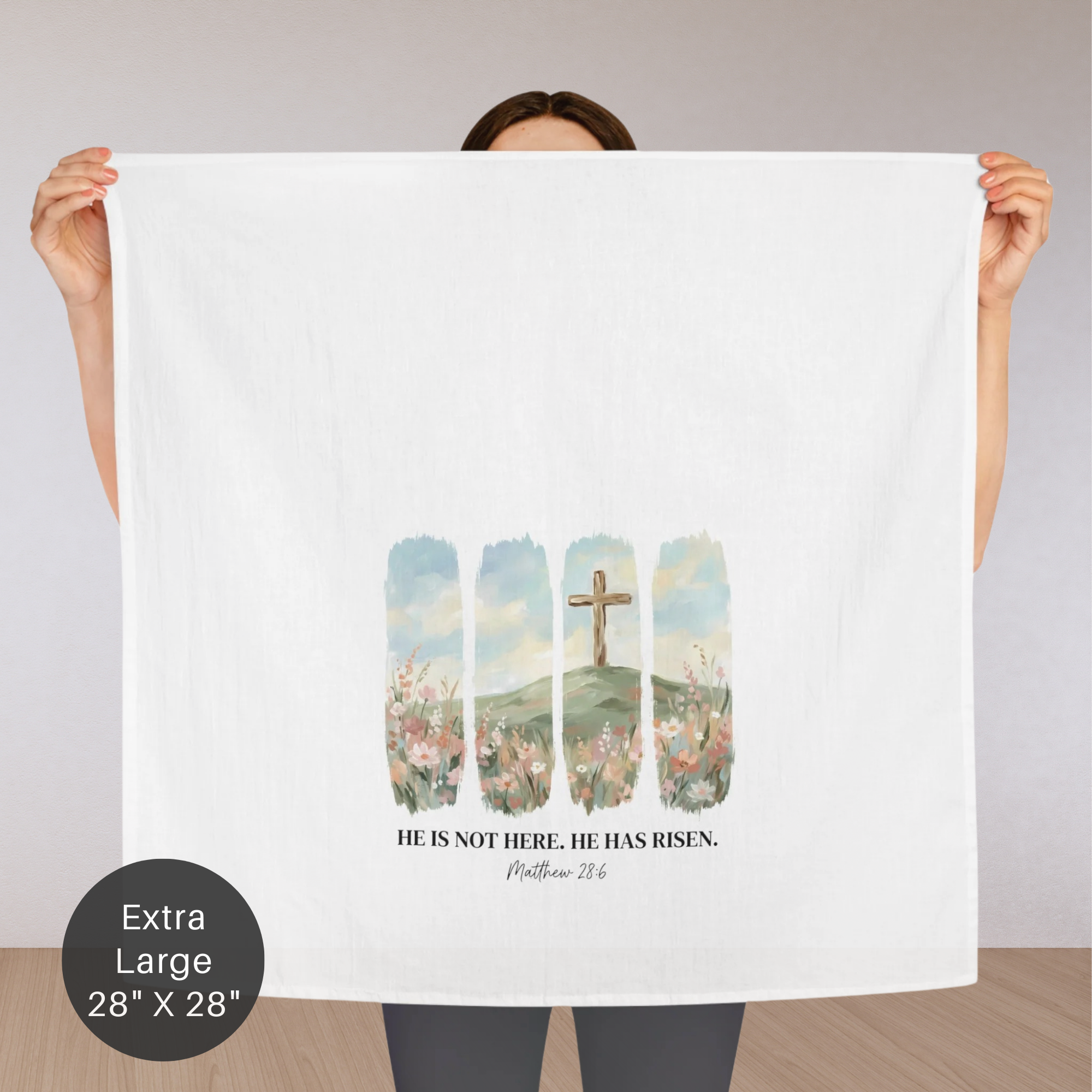 Person holding an extra large white tea towel with a religious design and text.