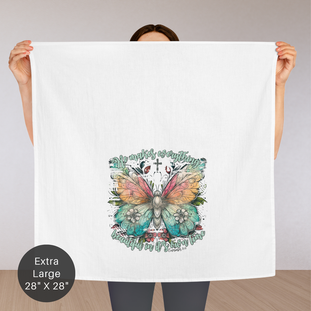 Person holding an extra large tea towel with a colorful butterfly design and text.