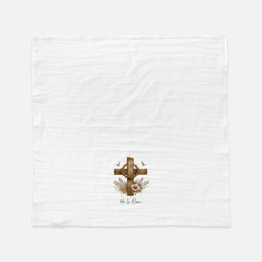 White tea towel with a cross and floral design in the corner on a white background