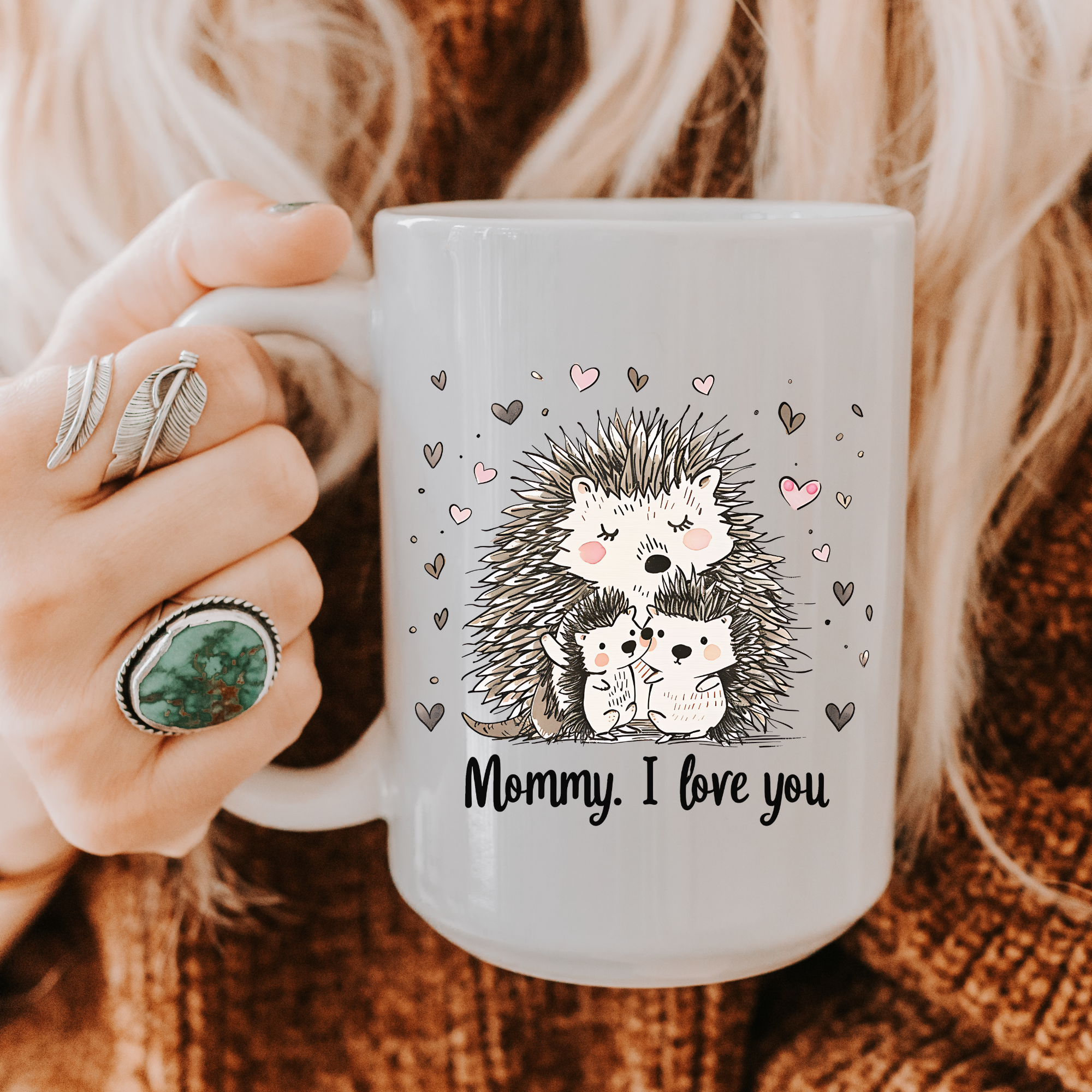 Person holding an 11oz mug with hedgehog design and 'Mommy, I love you' text.